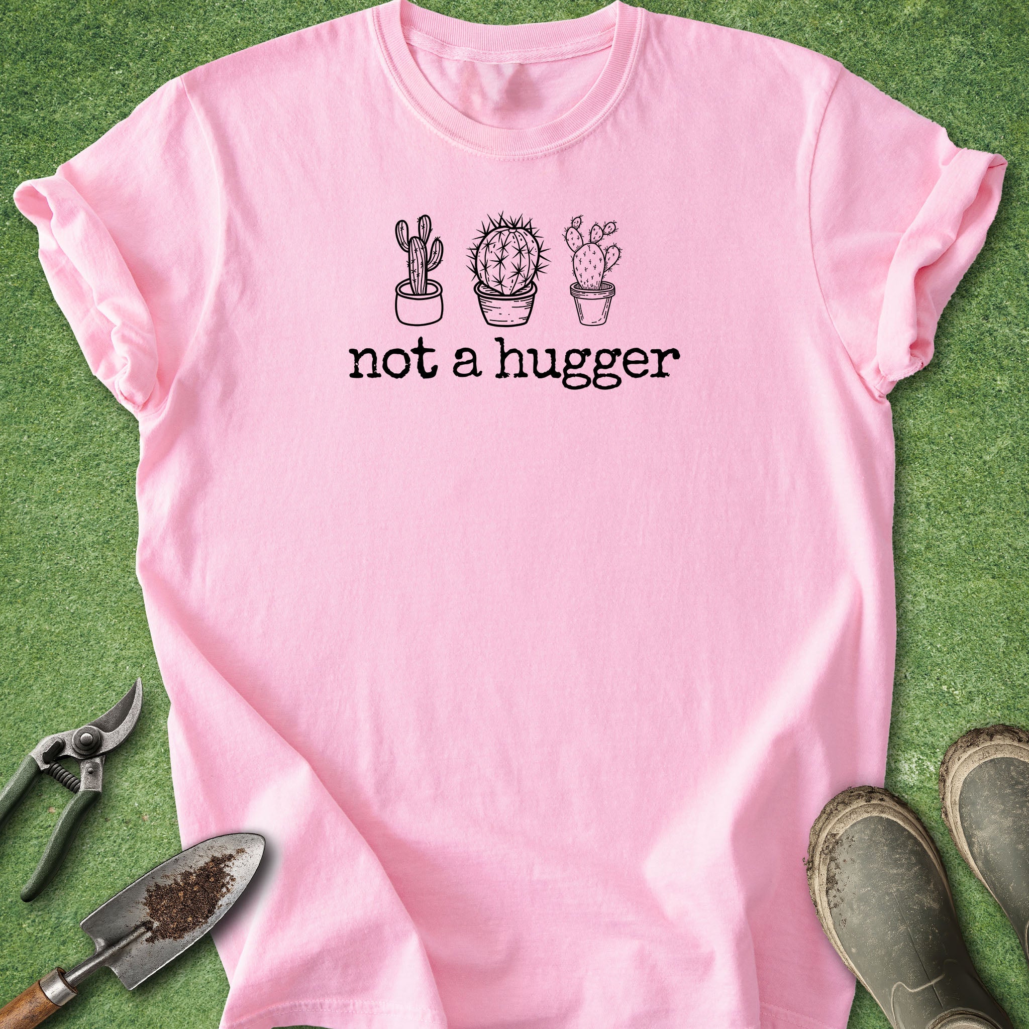 Pink t-shirt with cactus design and 'not a hugger' text on a green background