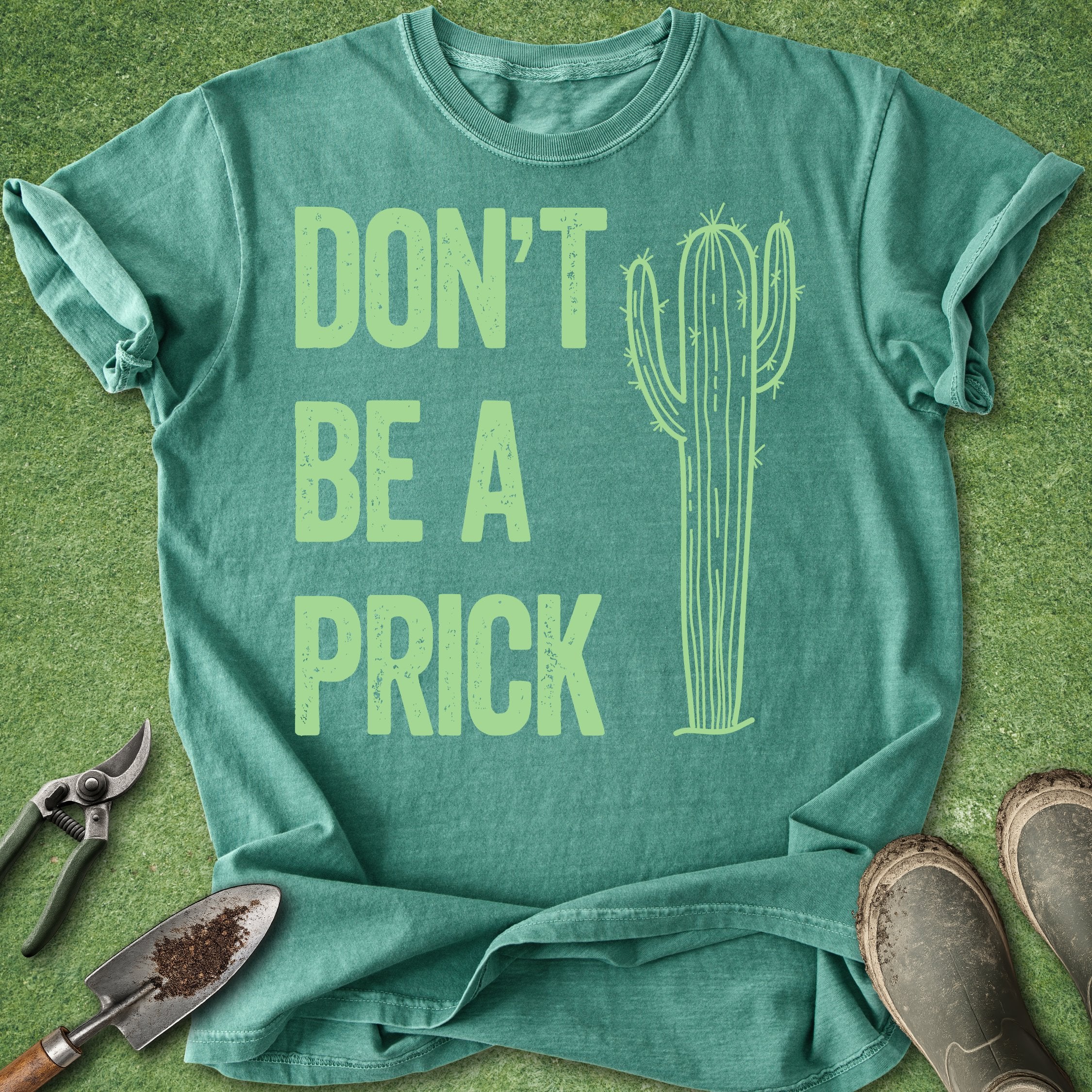 Green t-shirt with 'DON'T BE A PRICK' text and cactus graphic on a green background