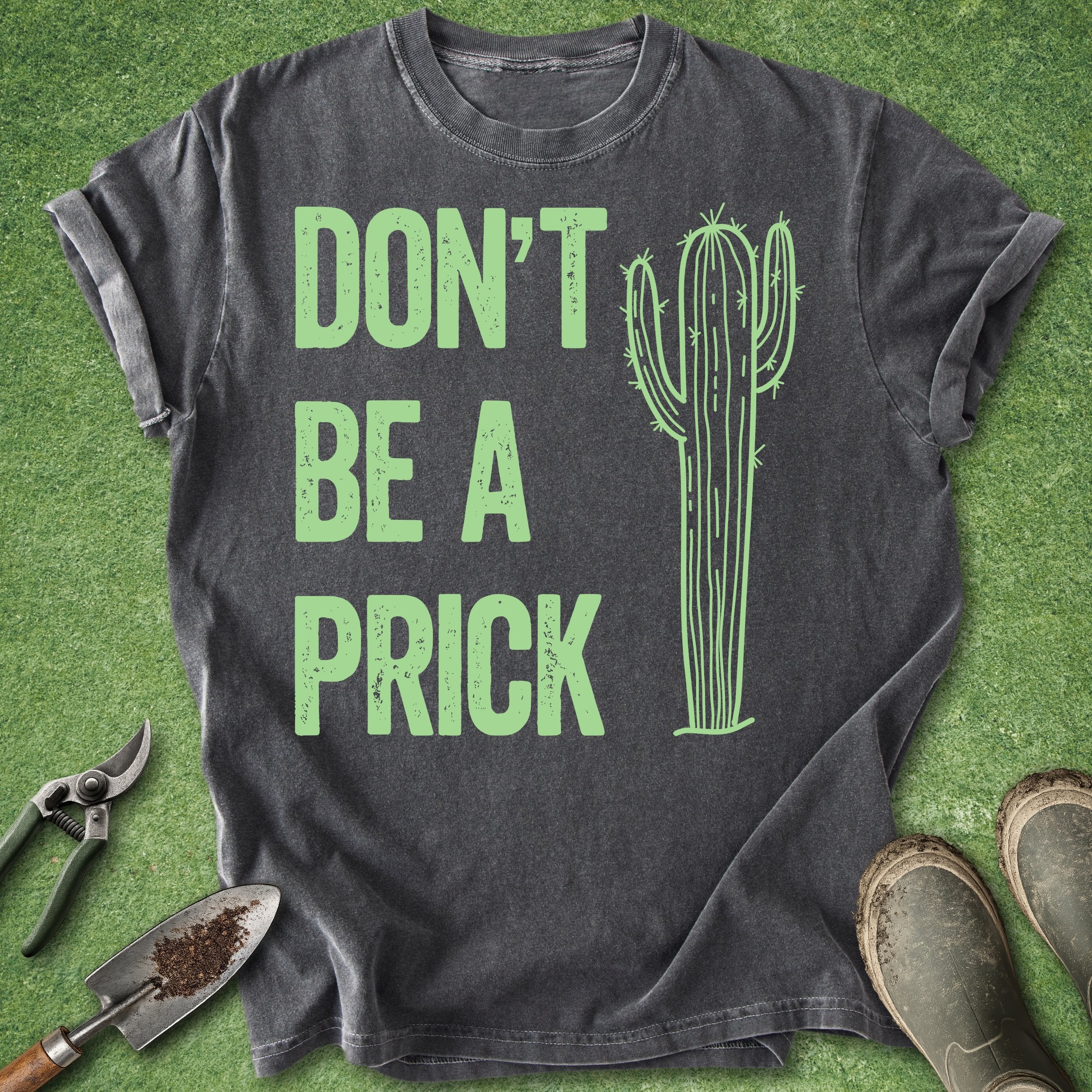 Black t-shirt with green cactus graphic and text on a grass background