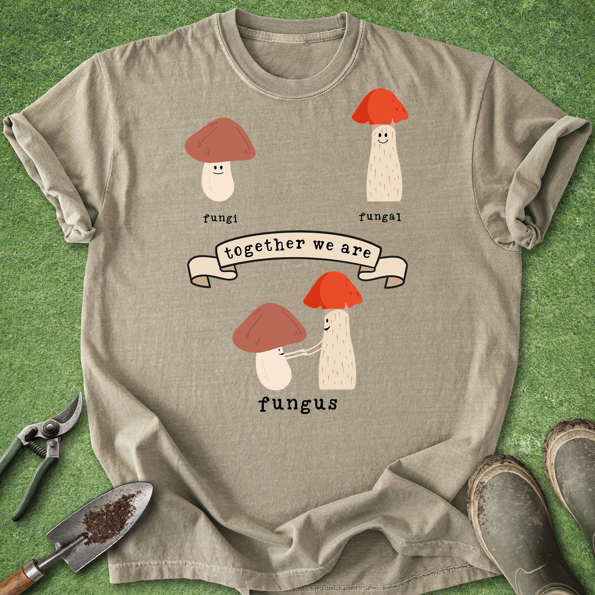 Beige t-shirt with mushroom design and text on a green grass background