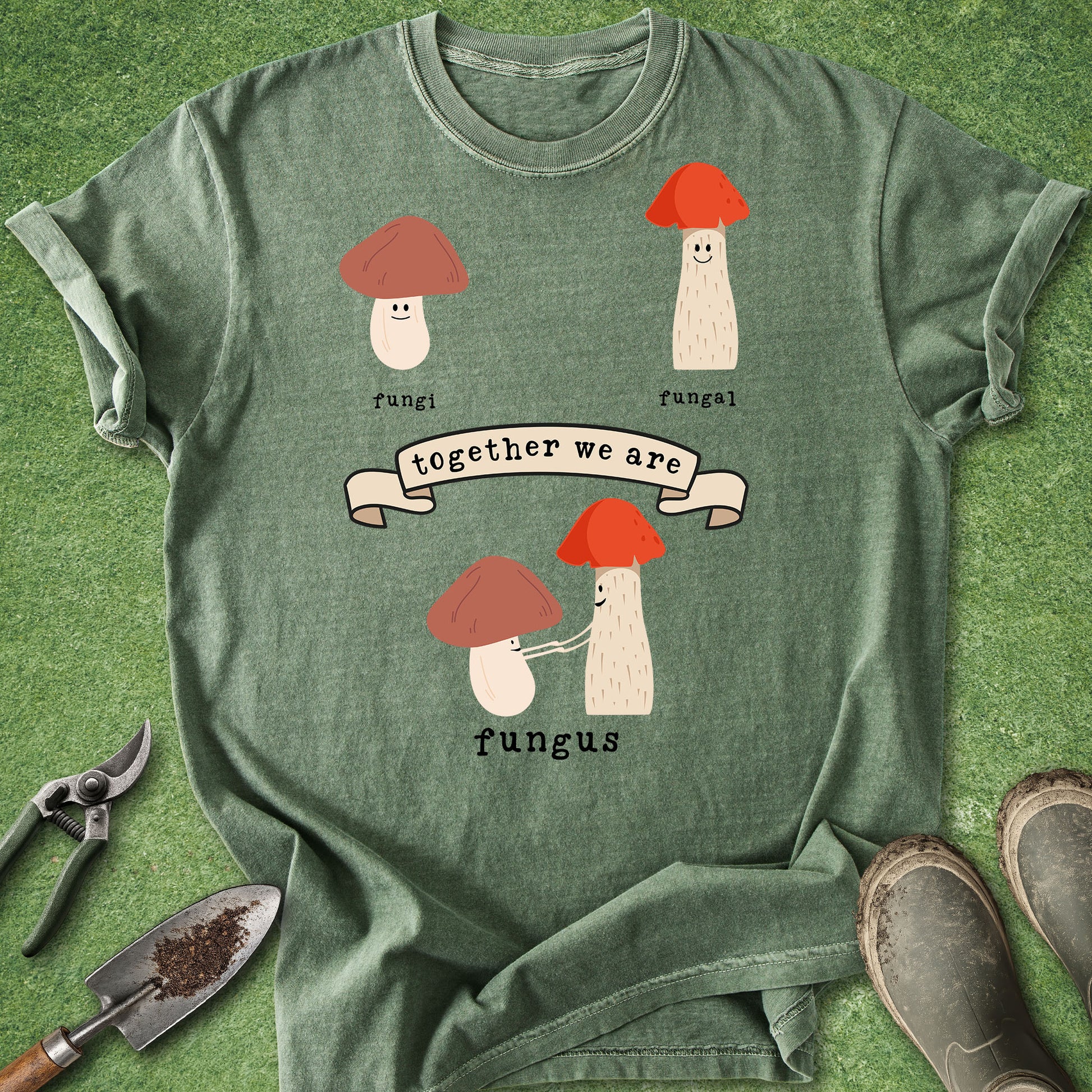 Green t-shirt with mushroom design and text on a grass background