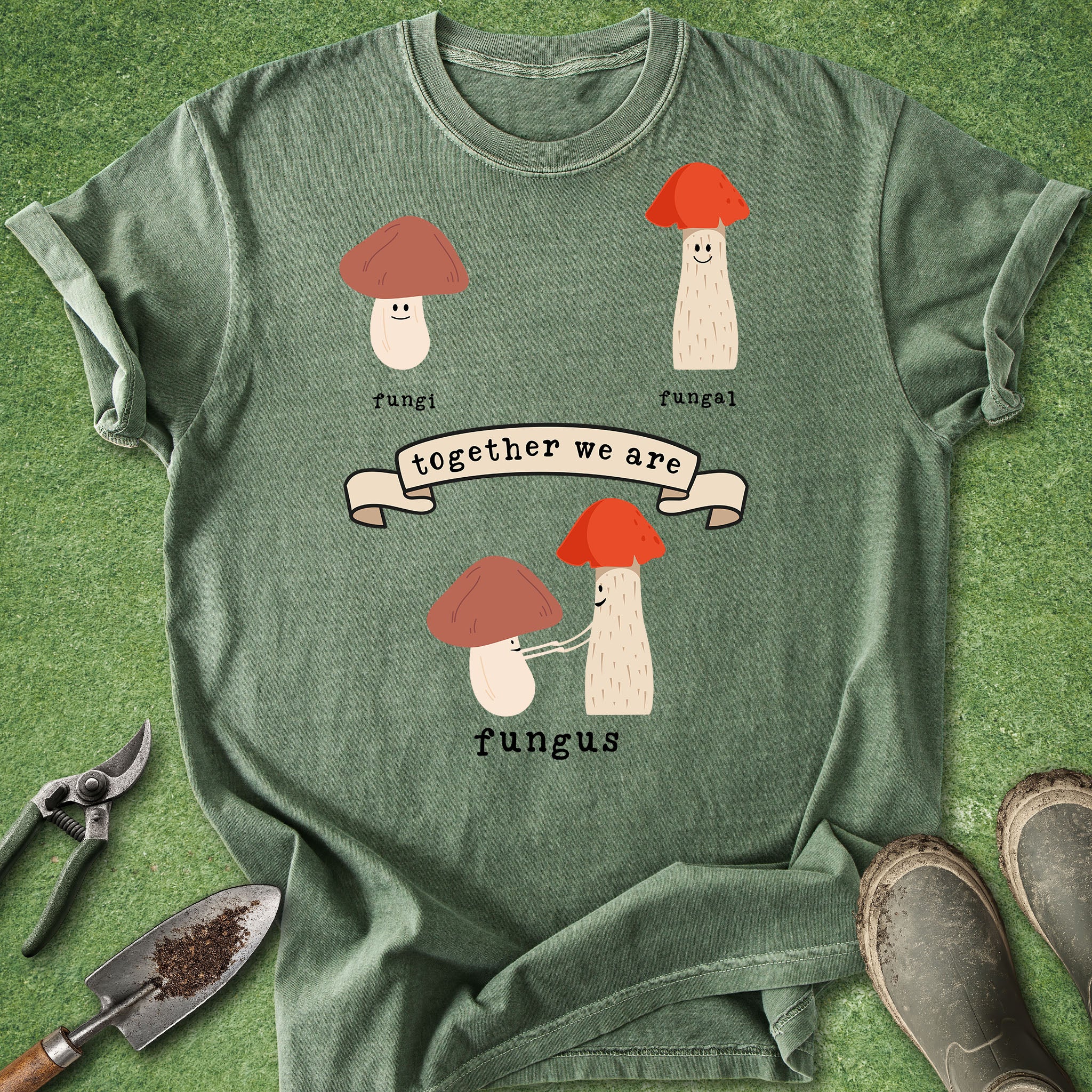 Green t-shirt with mushroom design and text on a grass background