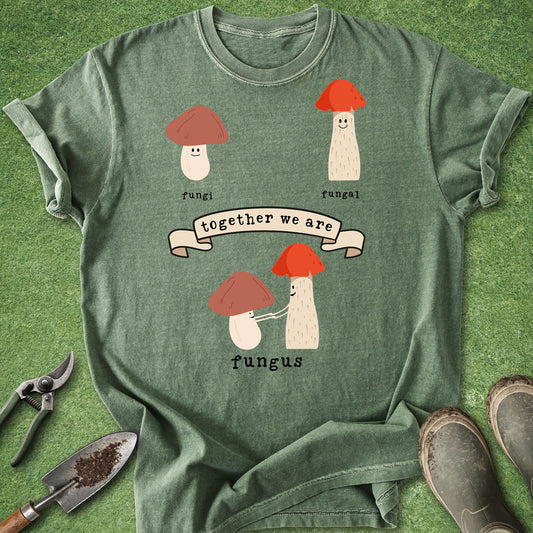 Green t-shirt with mushroom design and text on a grass background