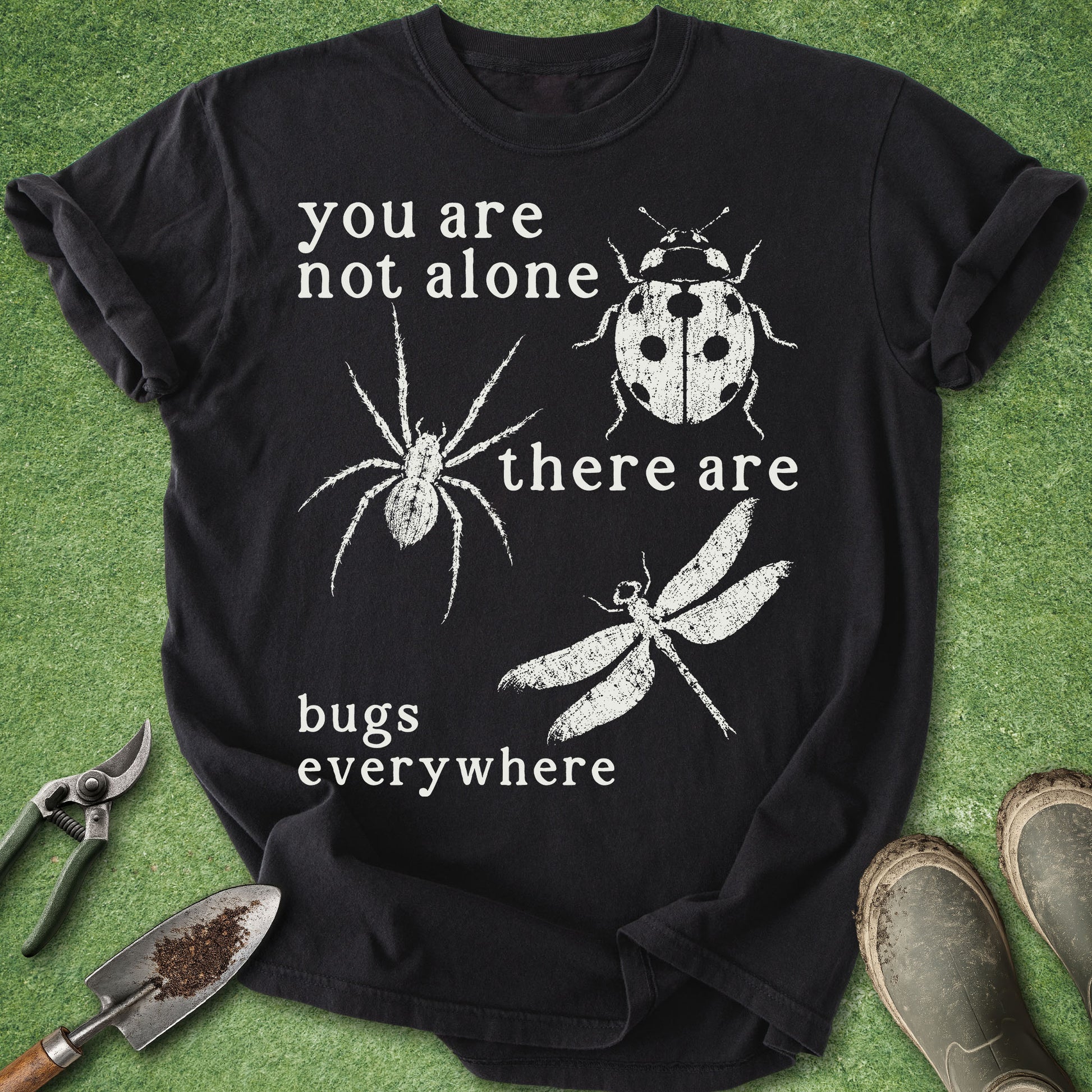 Black t-shirt with white text and insect illustrations on a green background