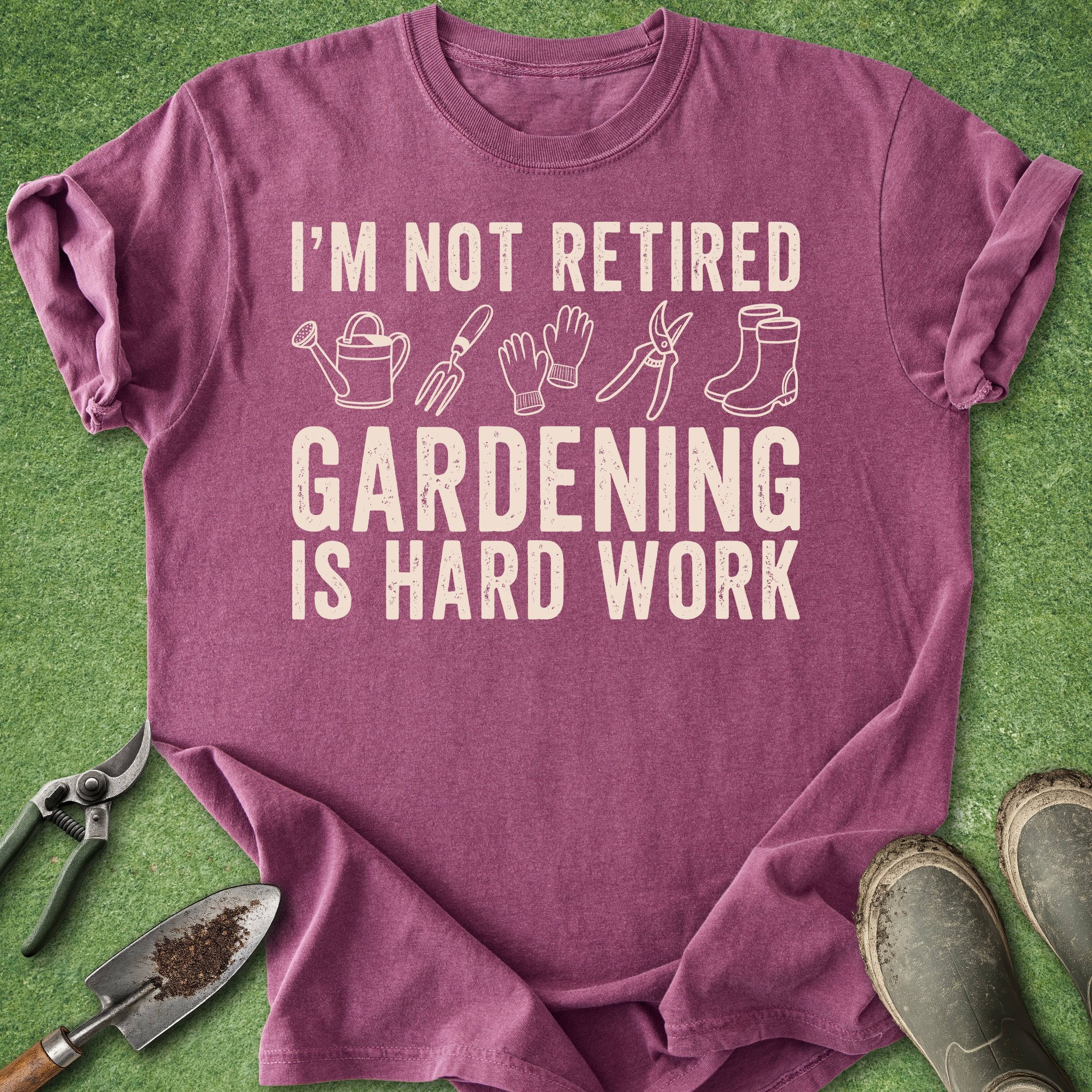 Purple t-shirt with gardening-themed text and icons on a grass background