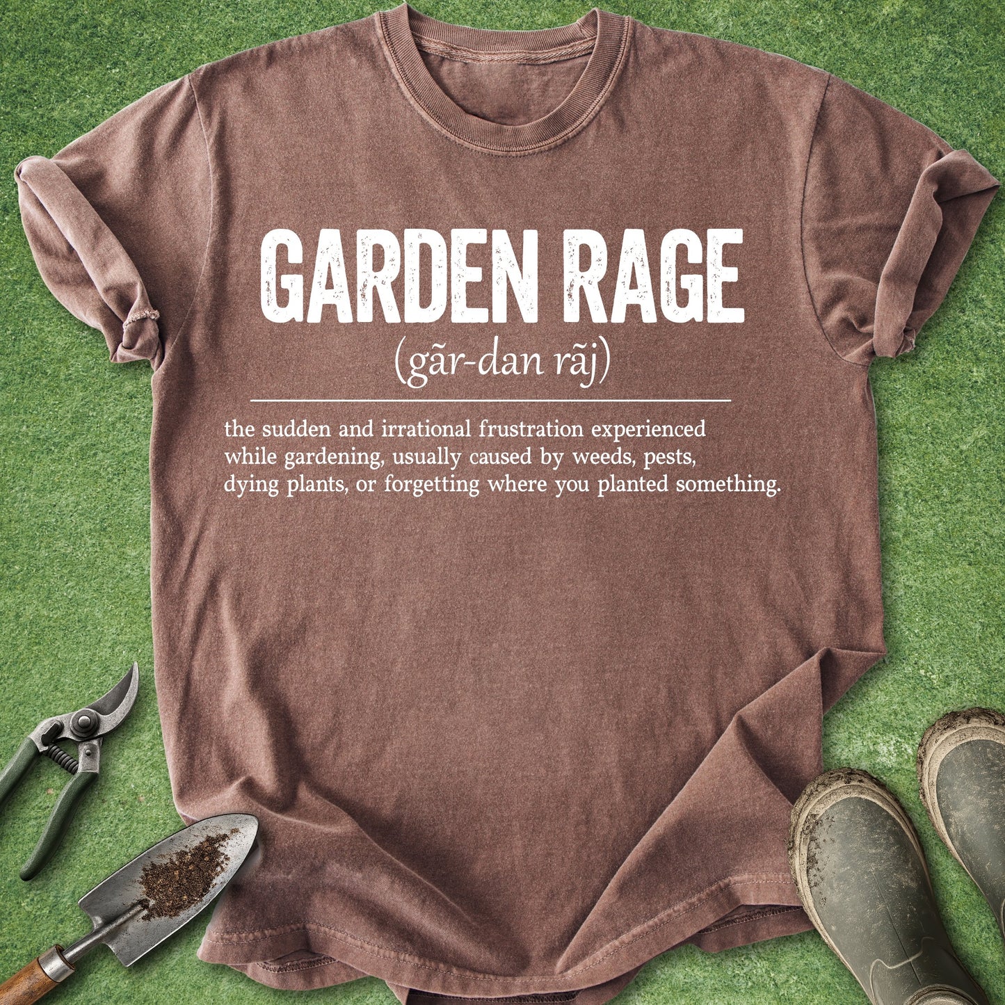Brown t-shirt with 'Garden Rage' definition on a grass background with gardening tools.