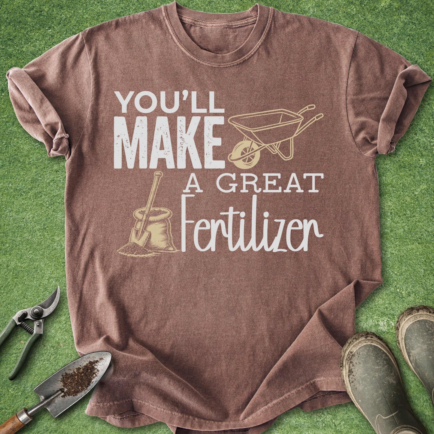 Brown t-shirt with gardening-themed text and graphics on a green background