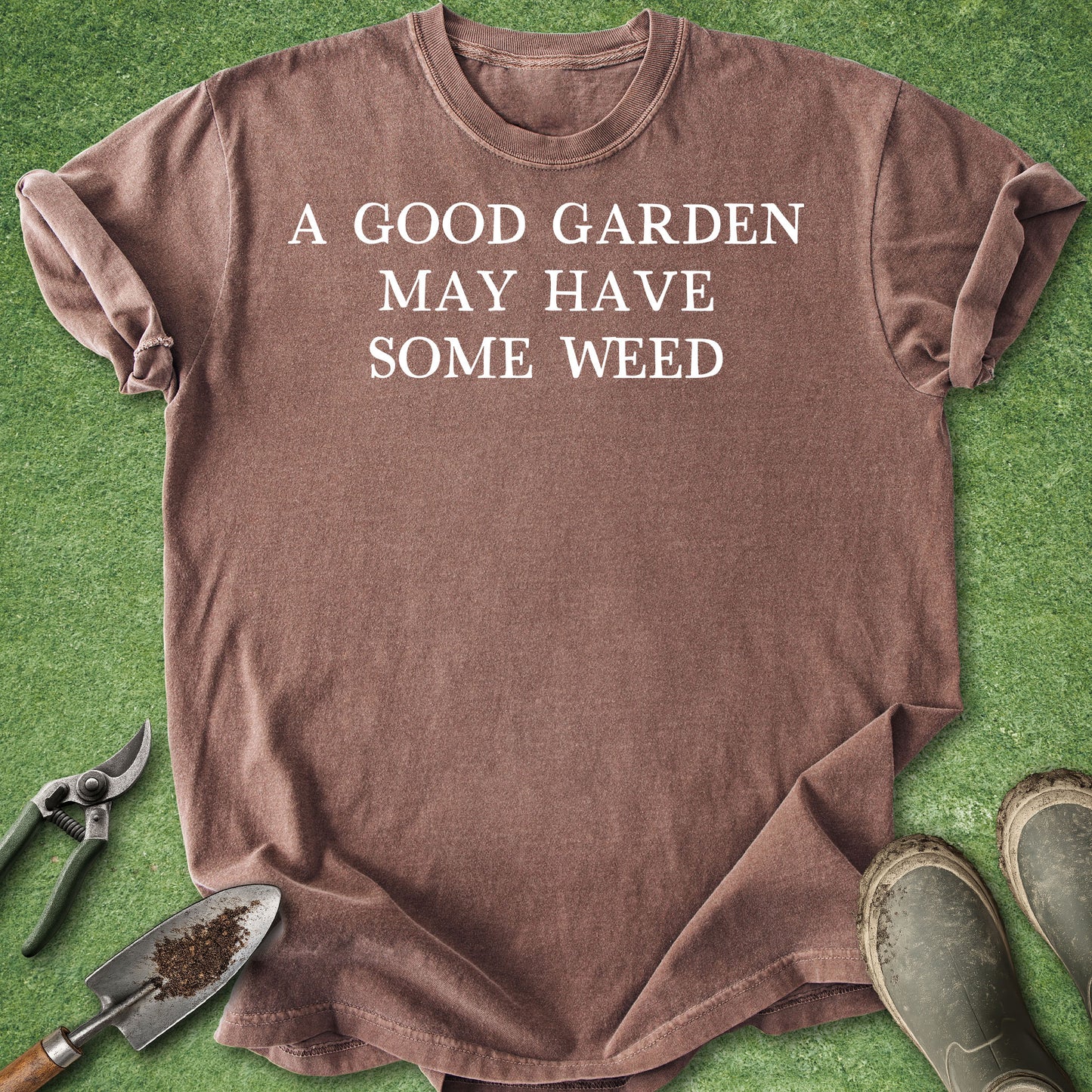 Espresso Comfort Colors t-shirt featuring the humorous gardening quote "A Good Garden May Have Some Weed" in clean white typography on the front.