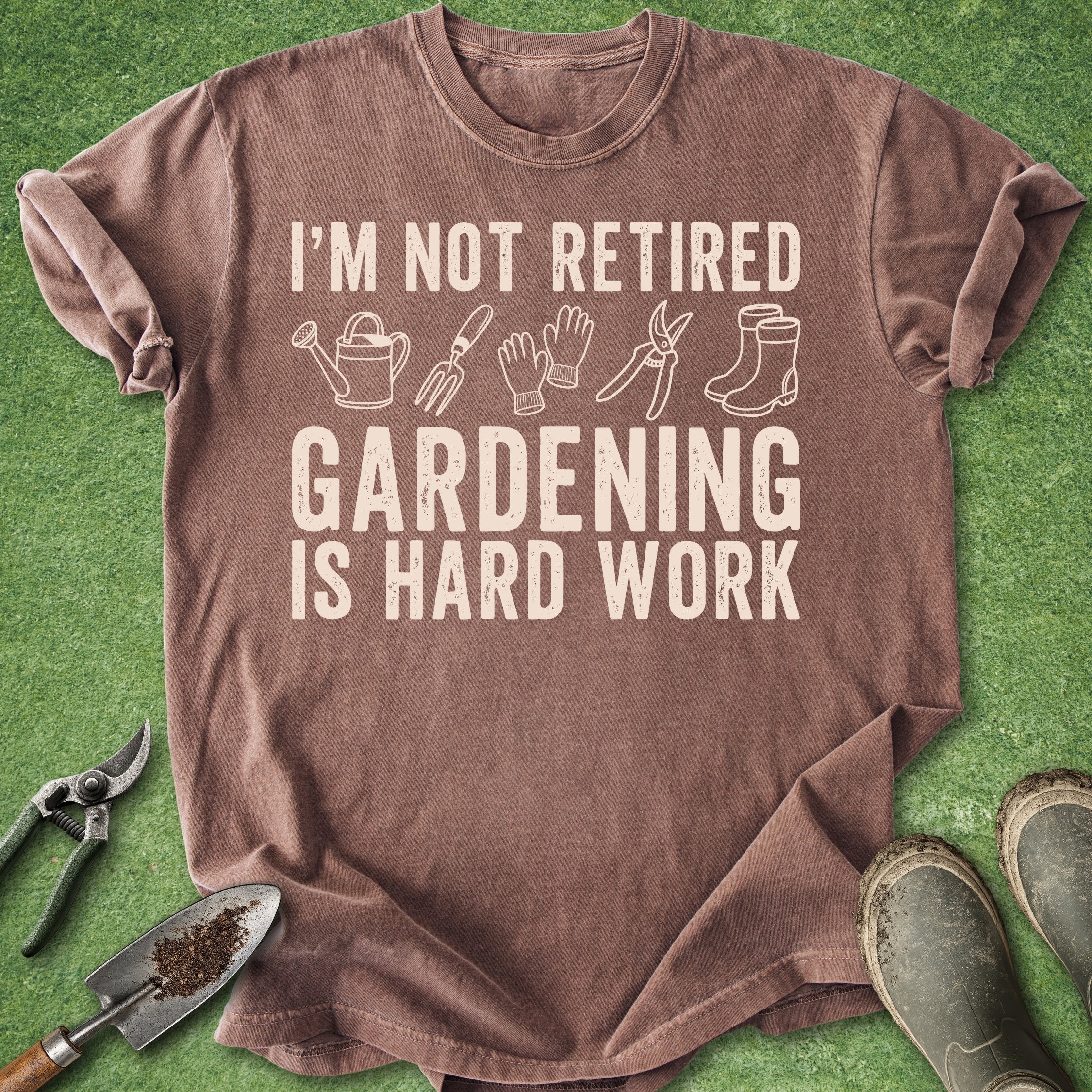 Brown t-shirt with gardening-themed text and icons on a green background