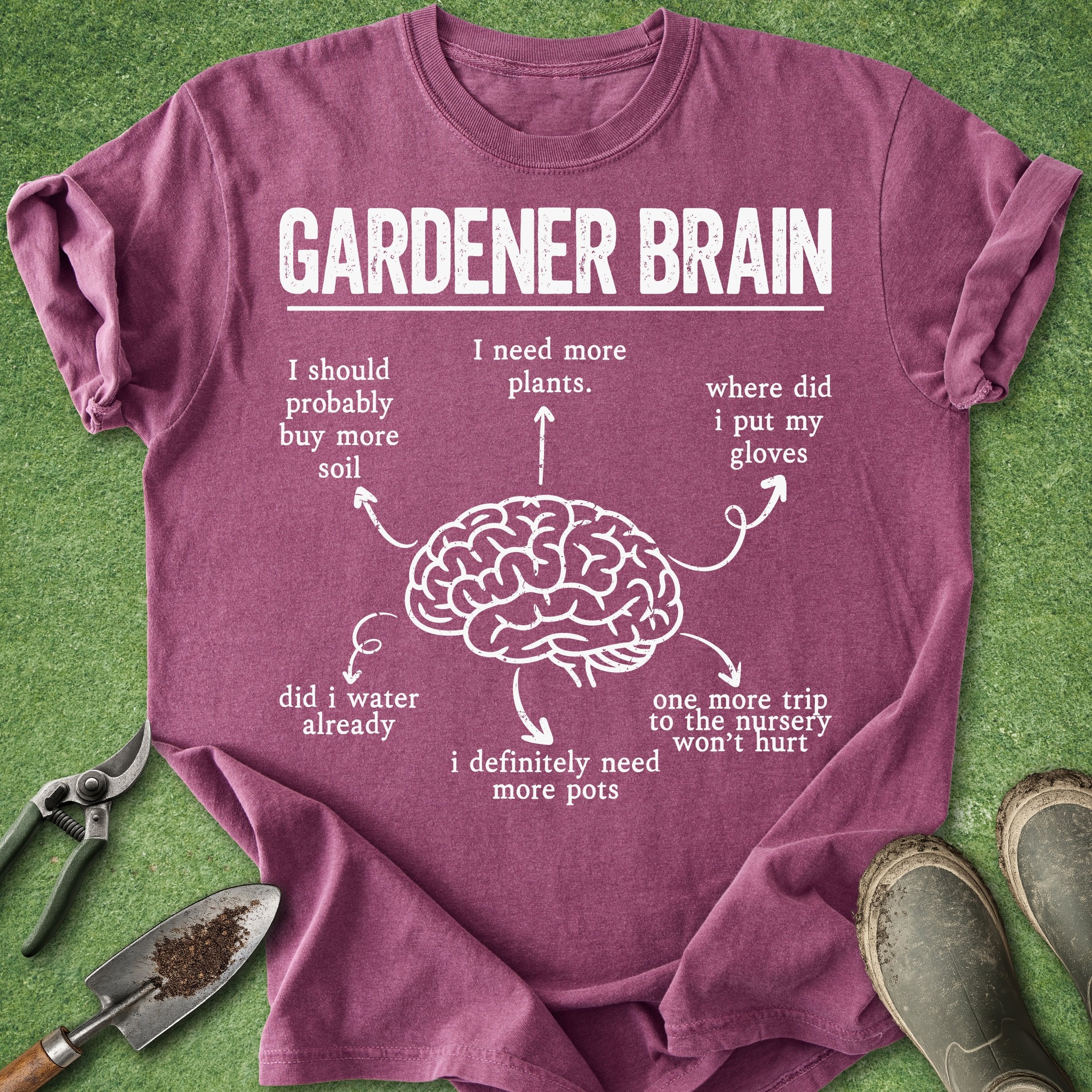 Purple t-shirt with 'Gardener Brain' graphic and text on a grass background