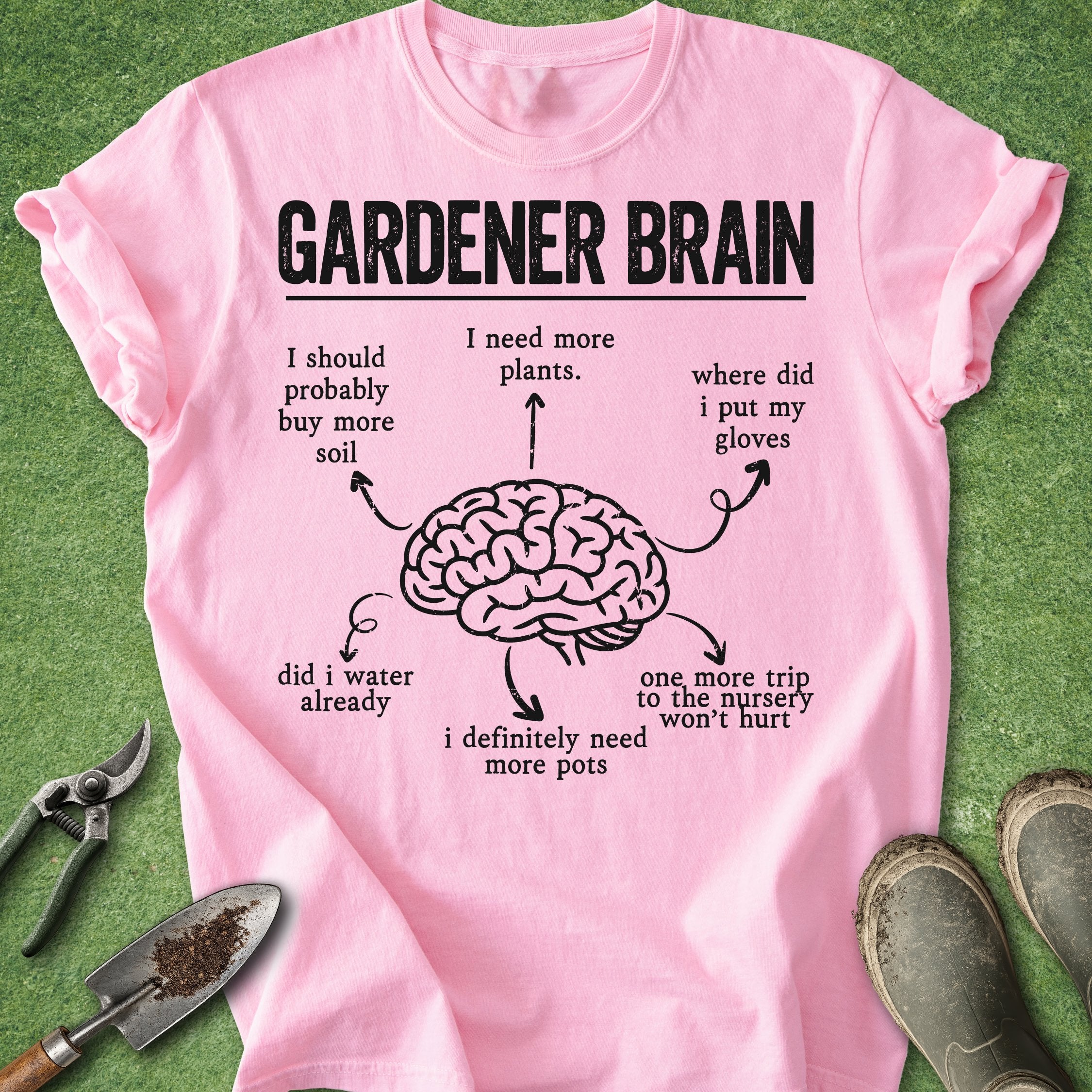 Pink t-shirt with 'Gardener Brain' graphic and text on a grass background