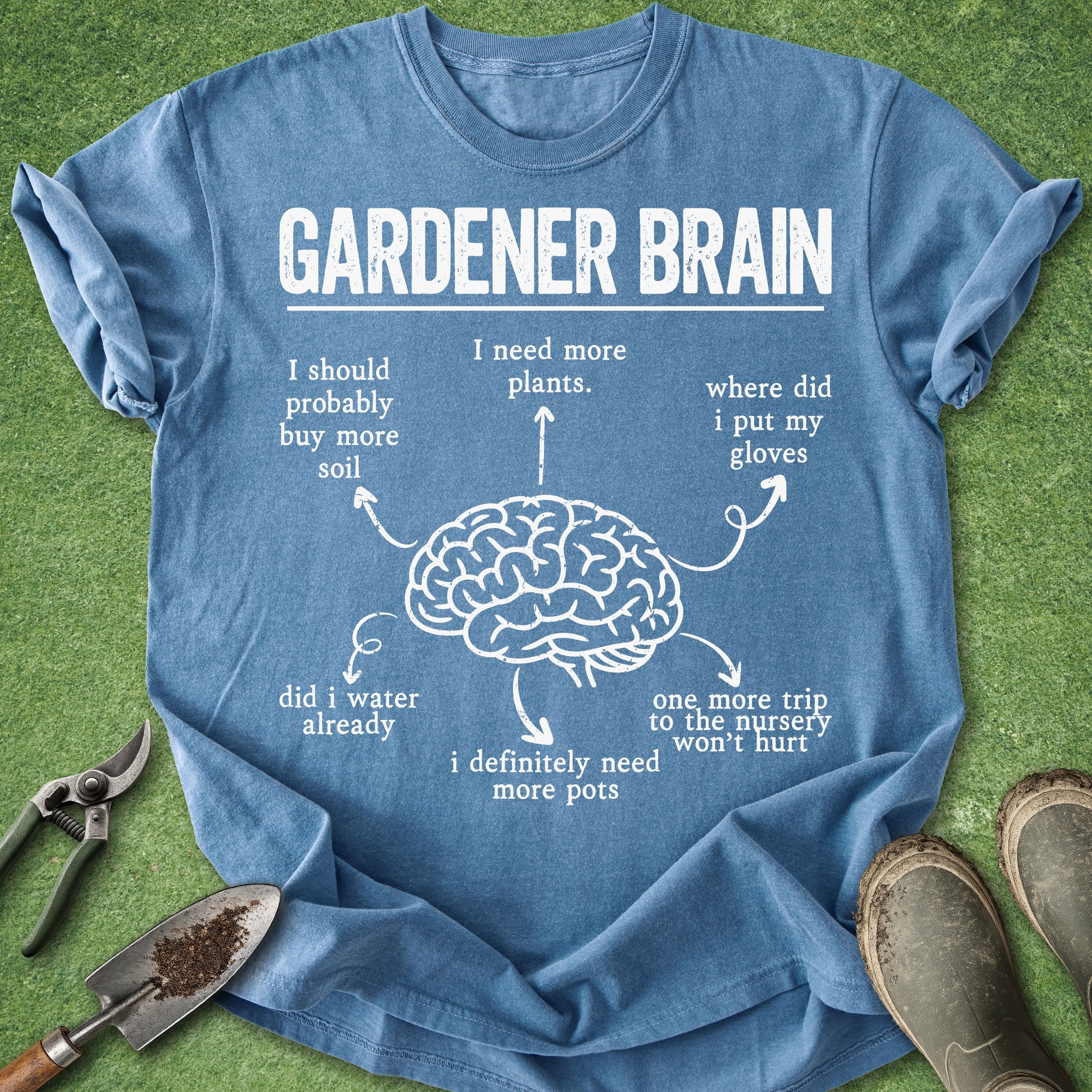Blue t-shirt with 'Gardener Brain' graphic and text on a grass background