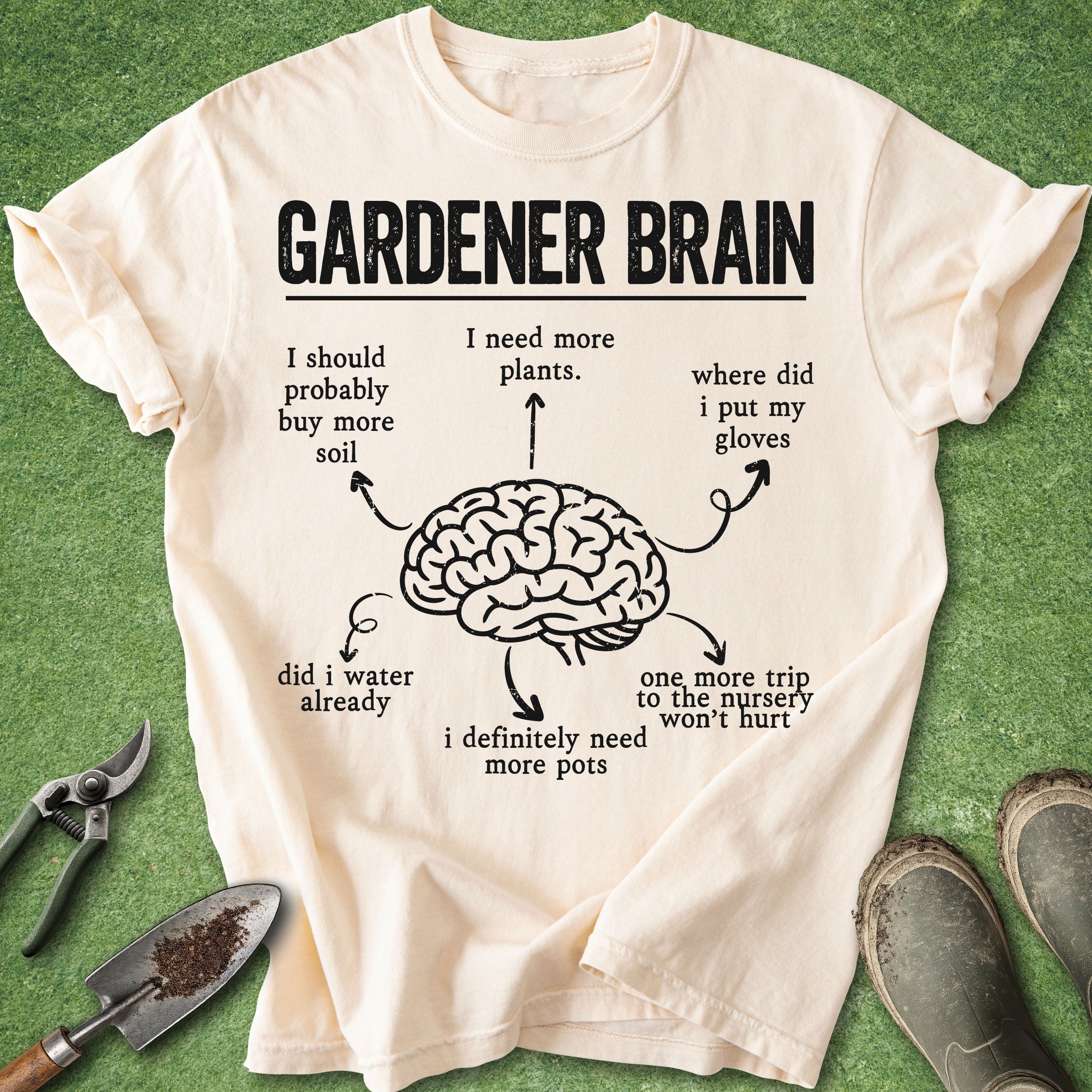 Beige t-shirt with 'Gardener Brain' graphic and text on a green background with gardening tools.