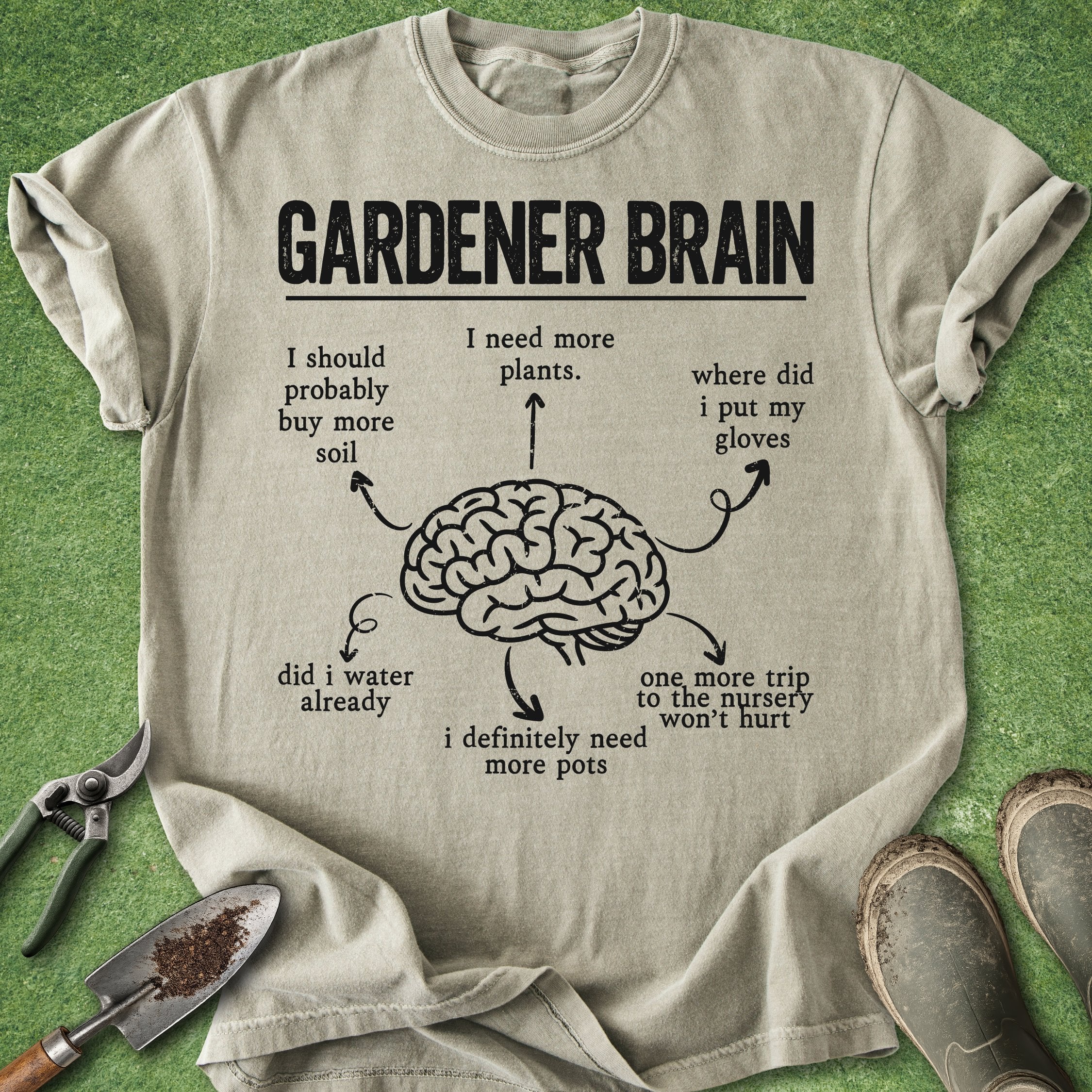 Beige t-shirt with 'Gardener Brain' graphic and gardening tools on a green background