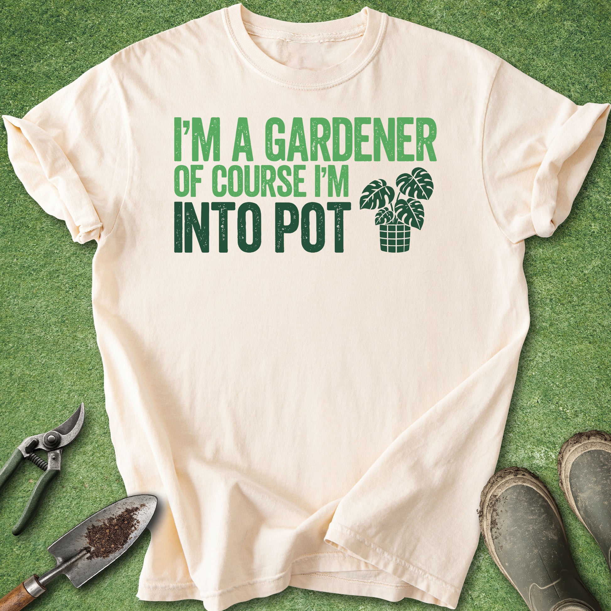 Ivory Comfort Colors t-shirt featuring the phrase "I'm a Gardener Of Course I'm Into Pot" in green typography with a potted monstera plant illustration.