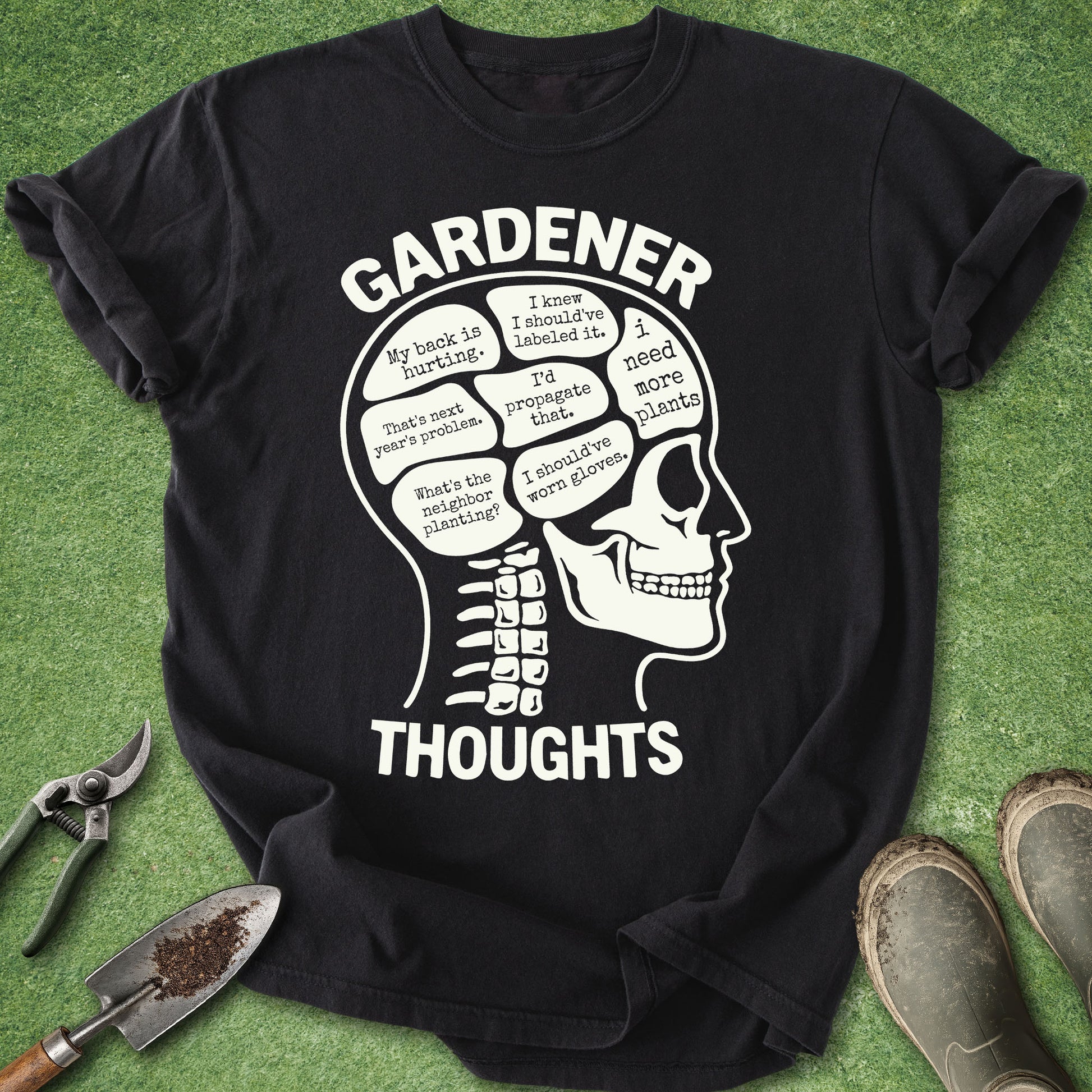 Black t-shirt with a white skull design and 'Gardener Thoughts' text on a green grass background.