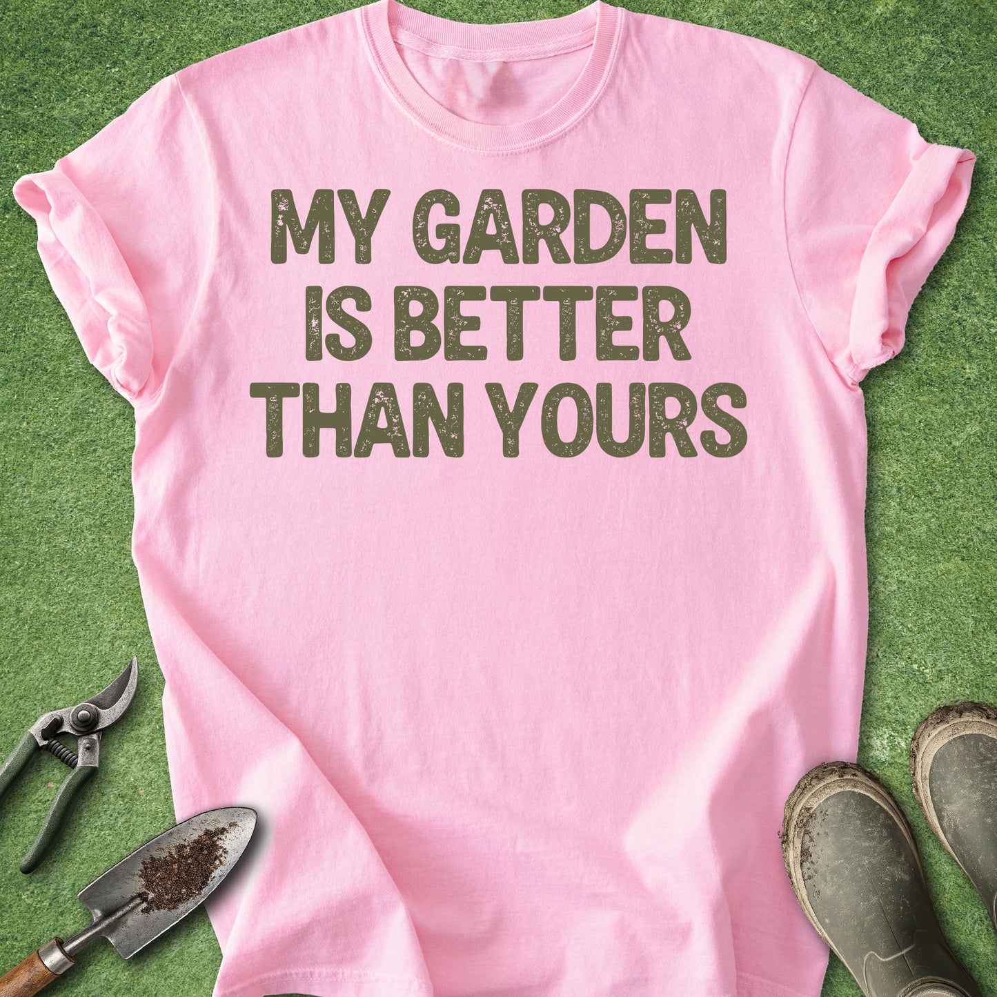 Pink t-shirt with 'My garden is better than yours' text on a green background with gardening tools.