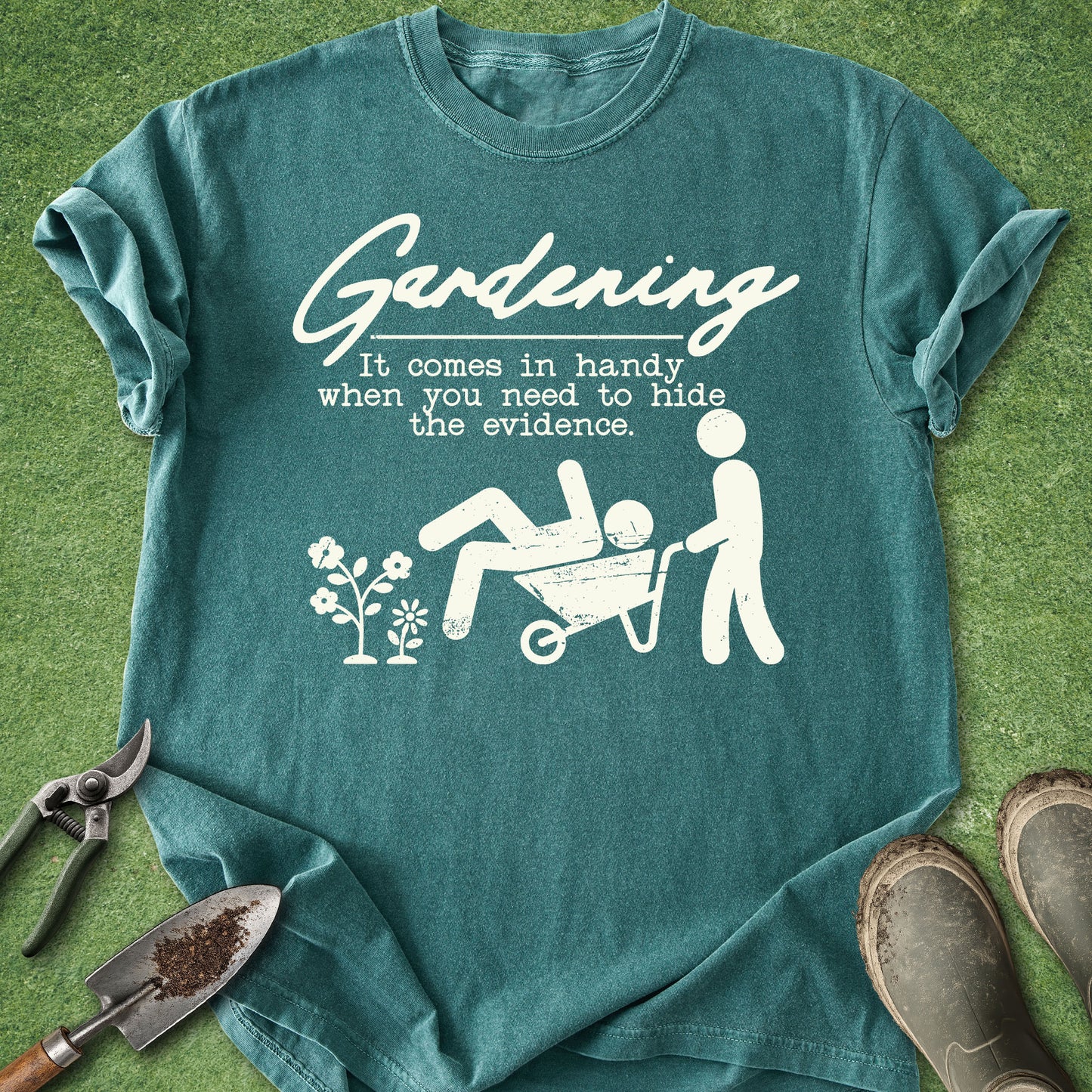 Teal t-shirt with white graphic and text on a grass background