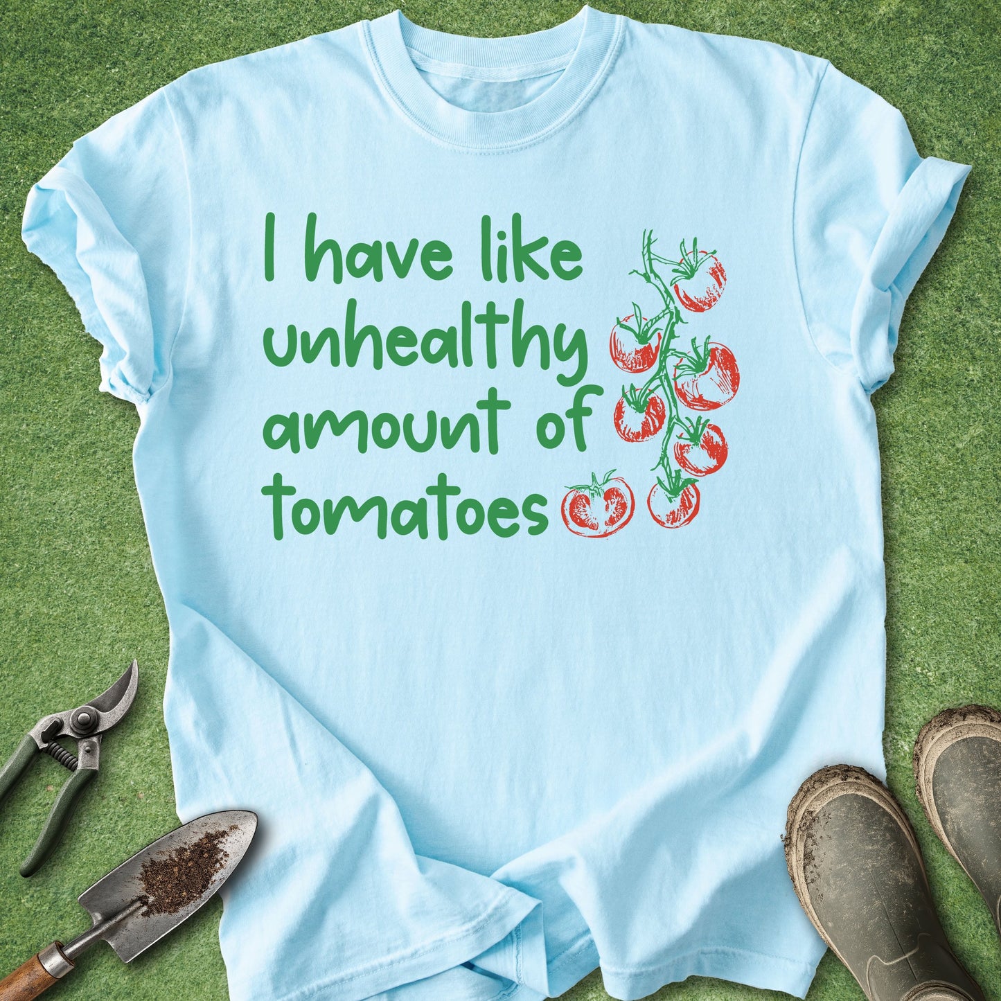 Light blue t-shirt with tomato-themed text and graphics on a grass background
