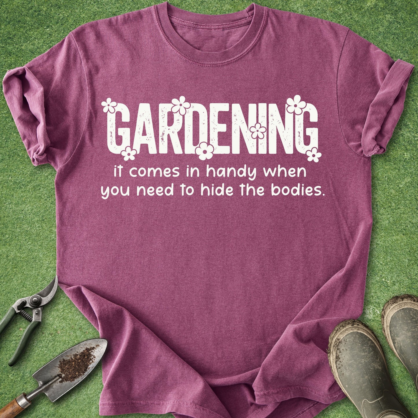 Purple t-shirt with humorous gardening text on a grass background