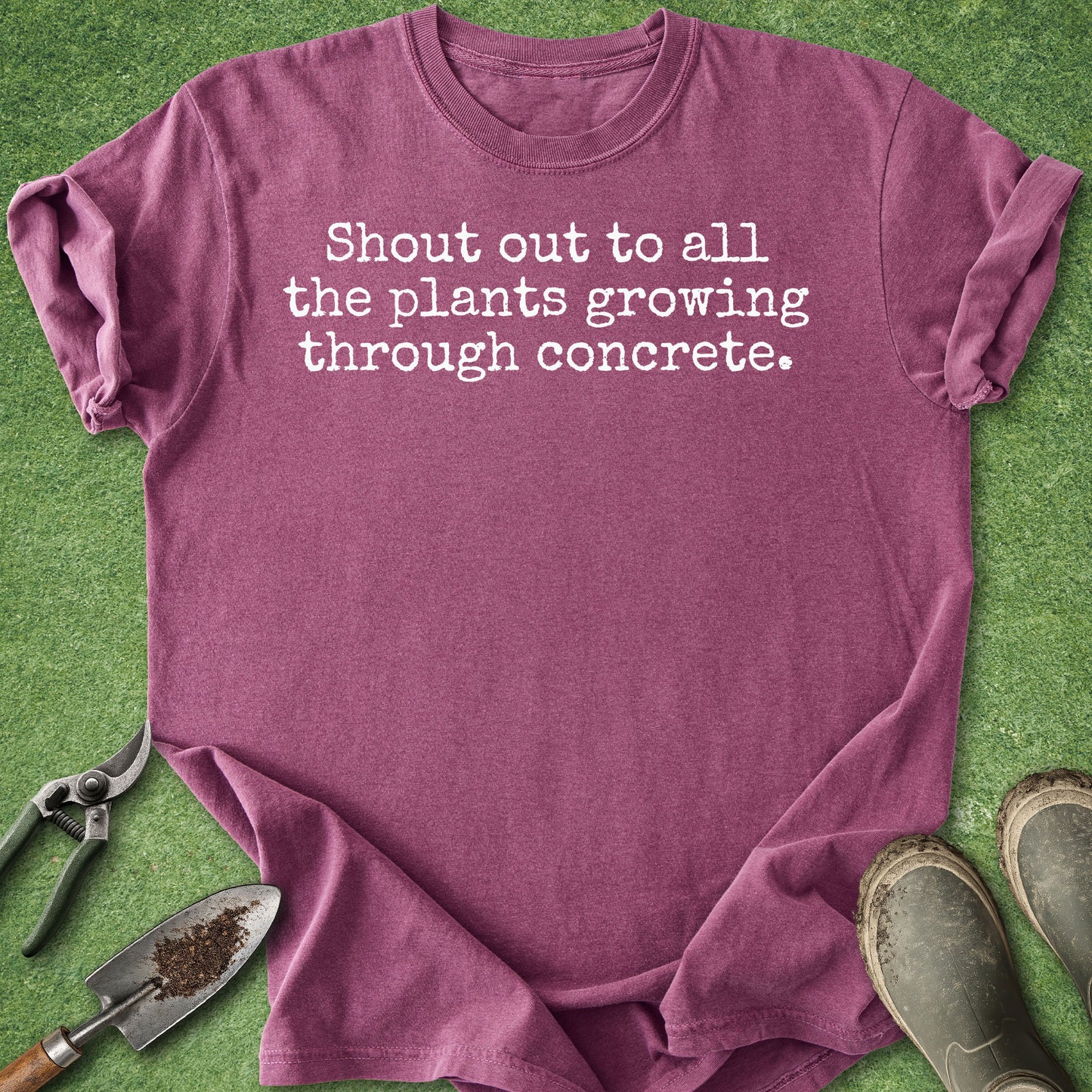 Comfort Colors berry blue t-shirt featuring the phrase "Shout out to all the plants growing through concrete." in a minimalist white typewriter-style font.