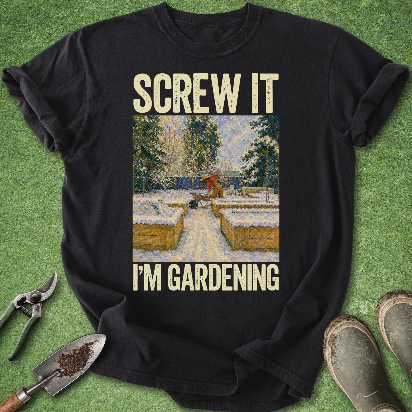 Black t-shirt with 'Screw it, I'm gardening' text and garden-themed graphic on a grass background.