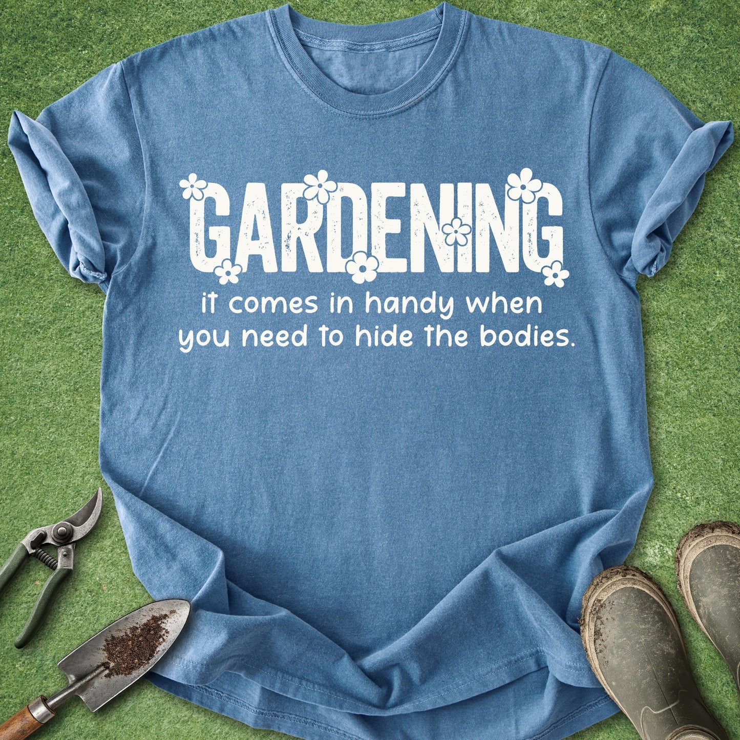 Blue t-shirt with humorous gardening text on a grass background