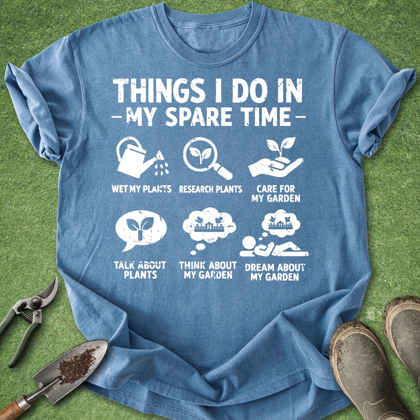 Blue t-shirt with gardening-themed text and icons on a grass background