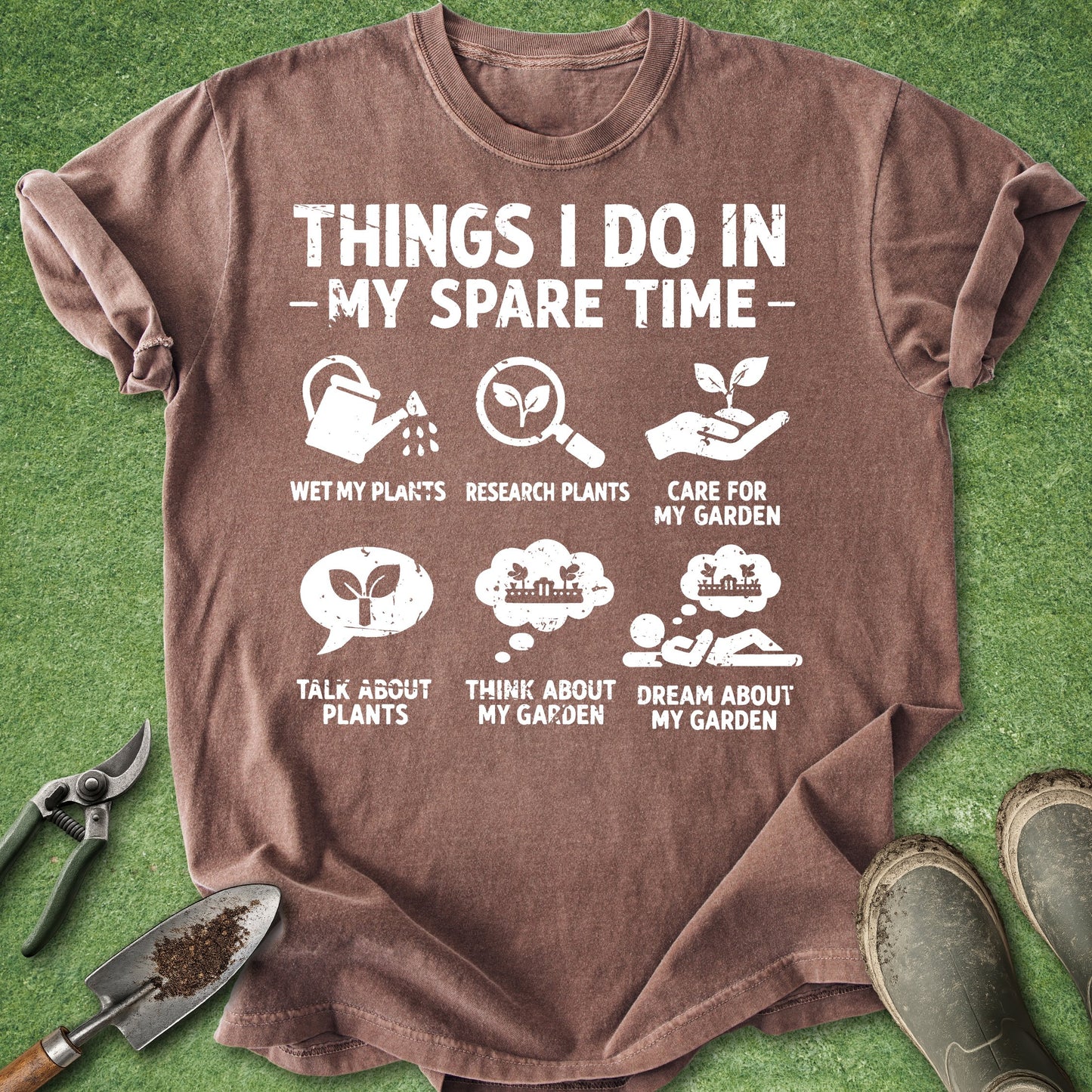 Brown t-shirt with gardening-themed text and icons on a grass background