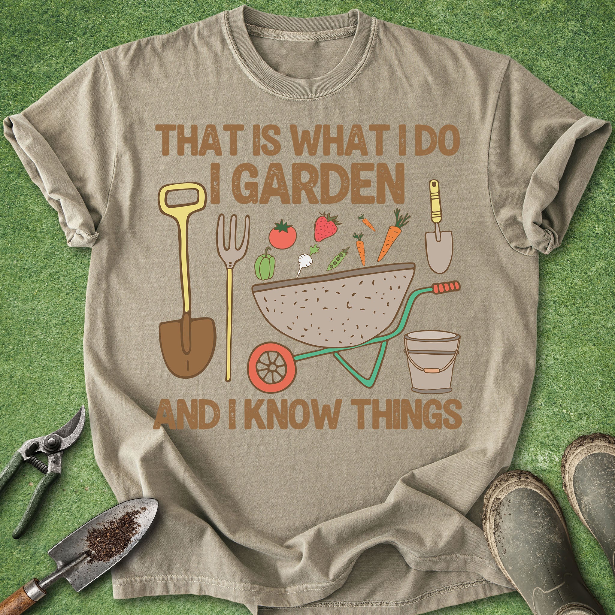 Beige t-shirt with gardening-themed design and tools on a grass background