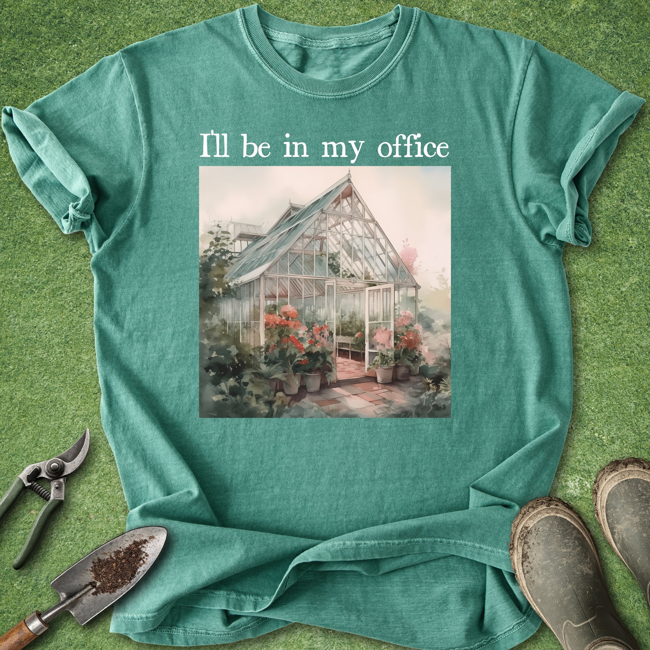 Green t-shirt with a greenhouse graphic and text 'I'll be in my office' on a grass background.