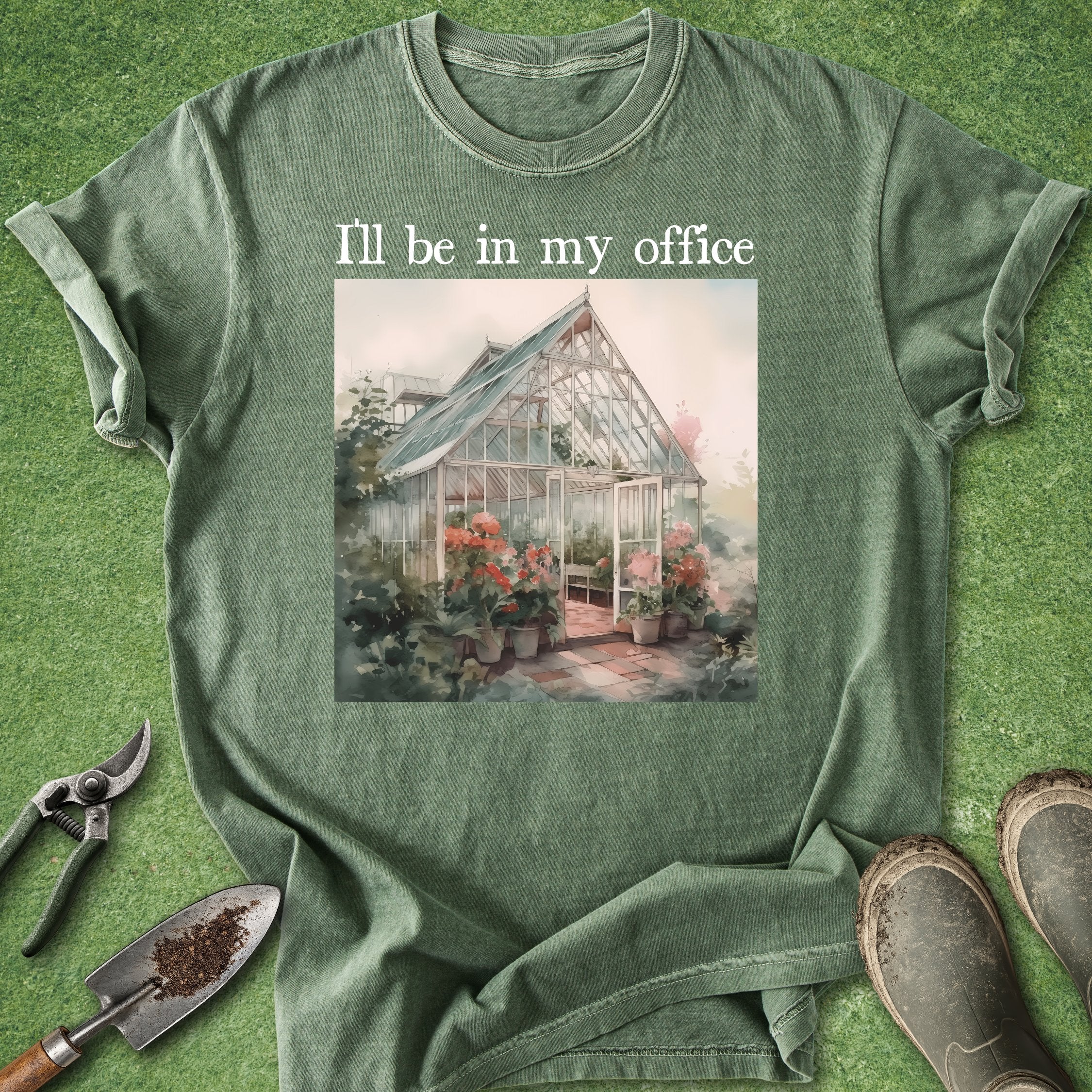 Green t-shirt with a greenhouse graphic and text 'I'll be in my office' on a grass background.