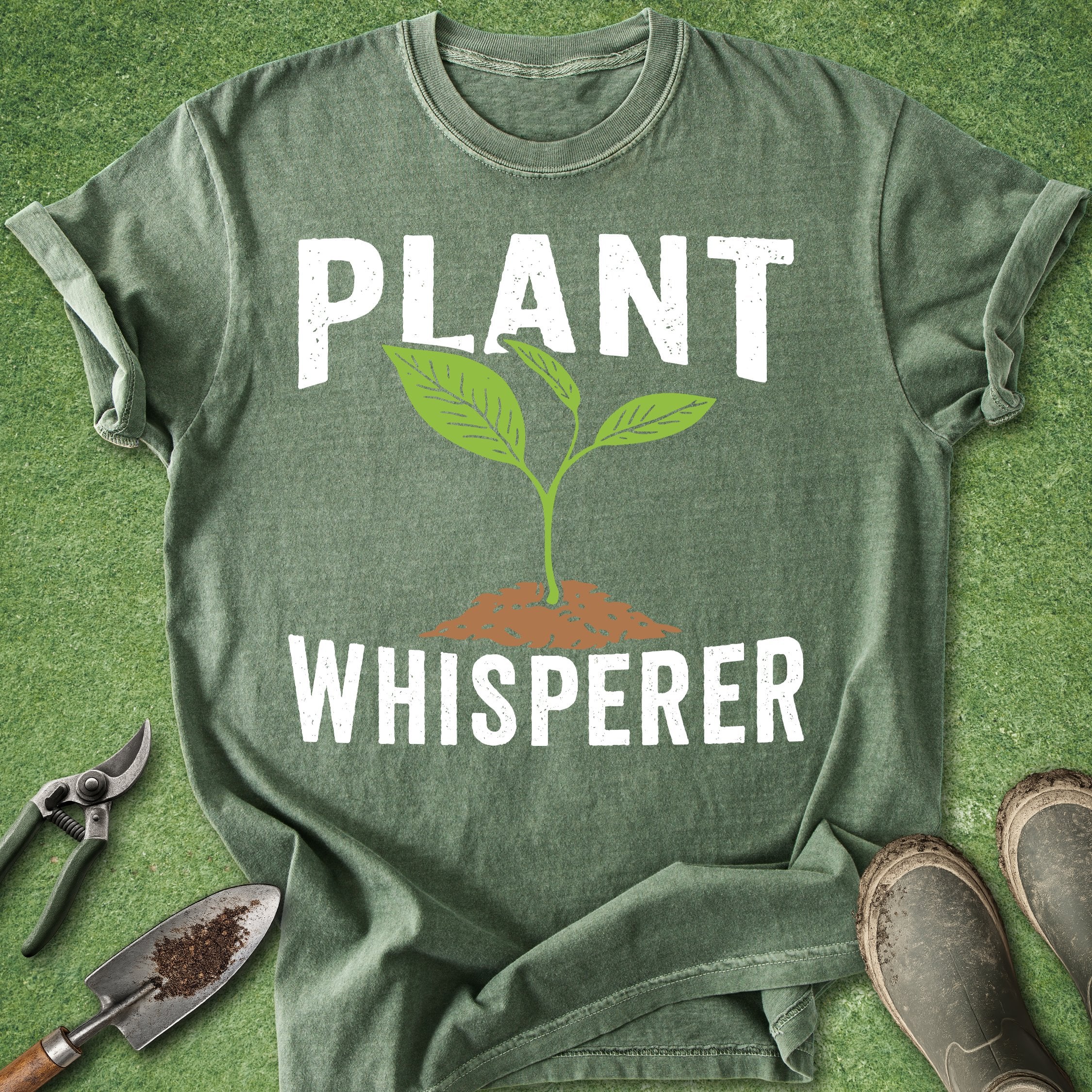 Green t-shirt with 'Plant Whisperer' text and graphic on a grass background