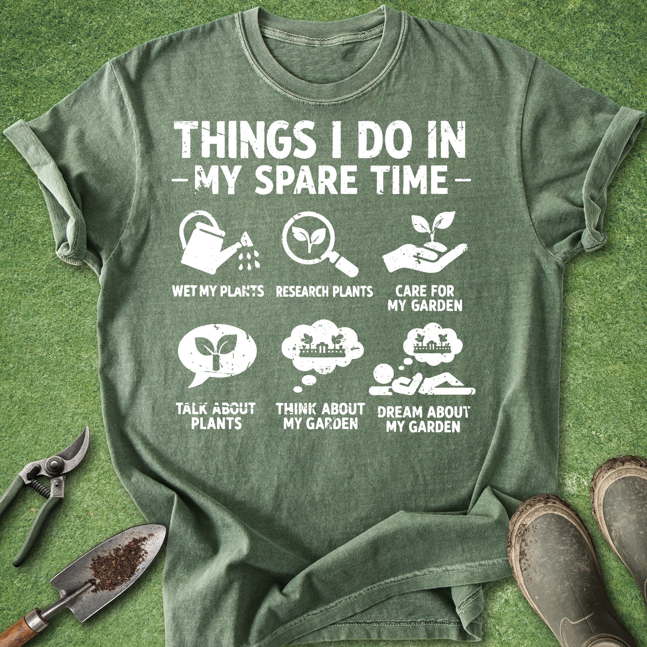 Green t-shirt with gardening-themed text and icons on a grass background