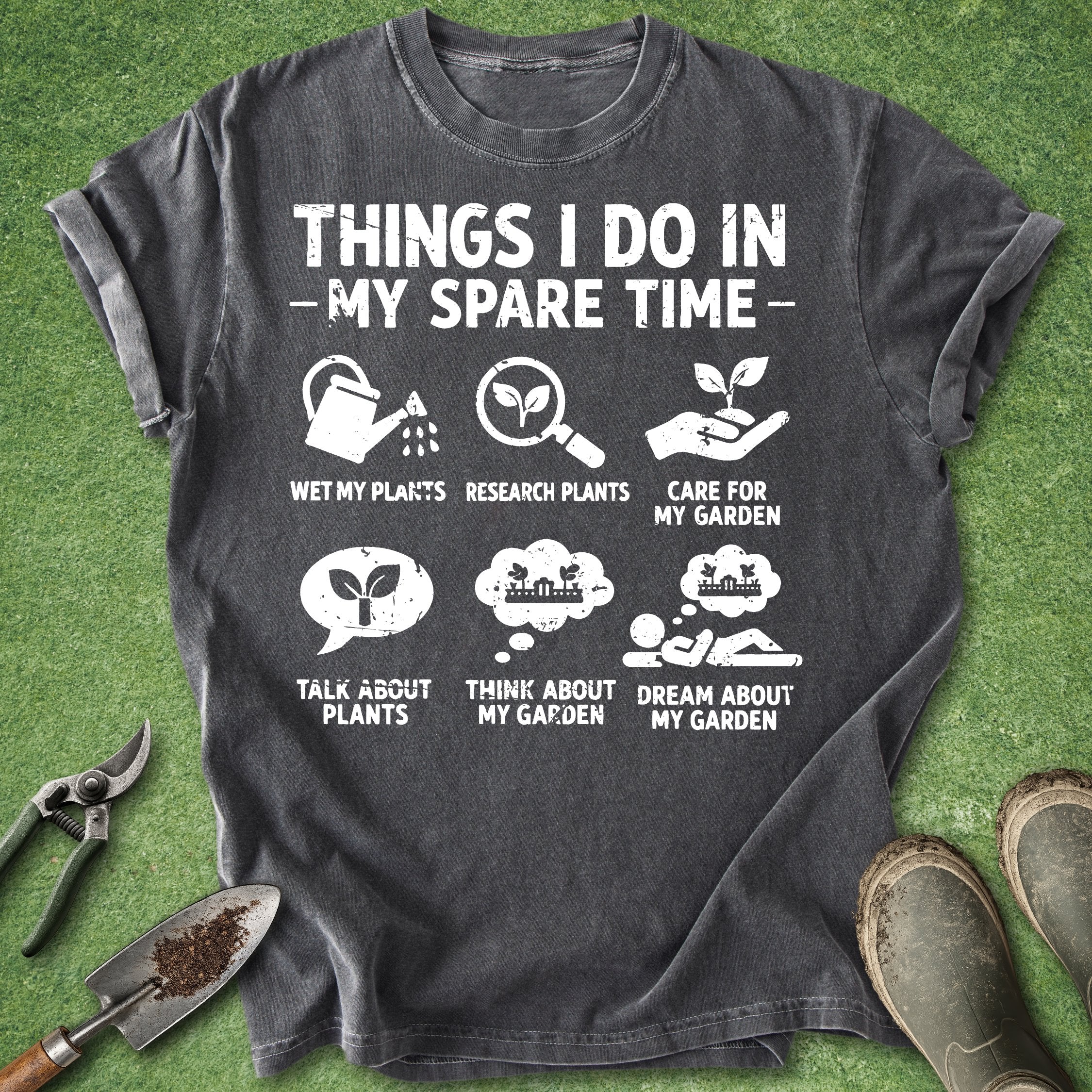 Gray t-shirt with gardening-themed text and icons on a green grass background