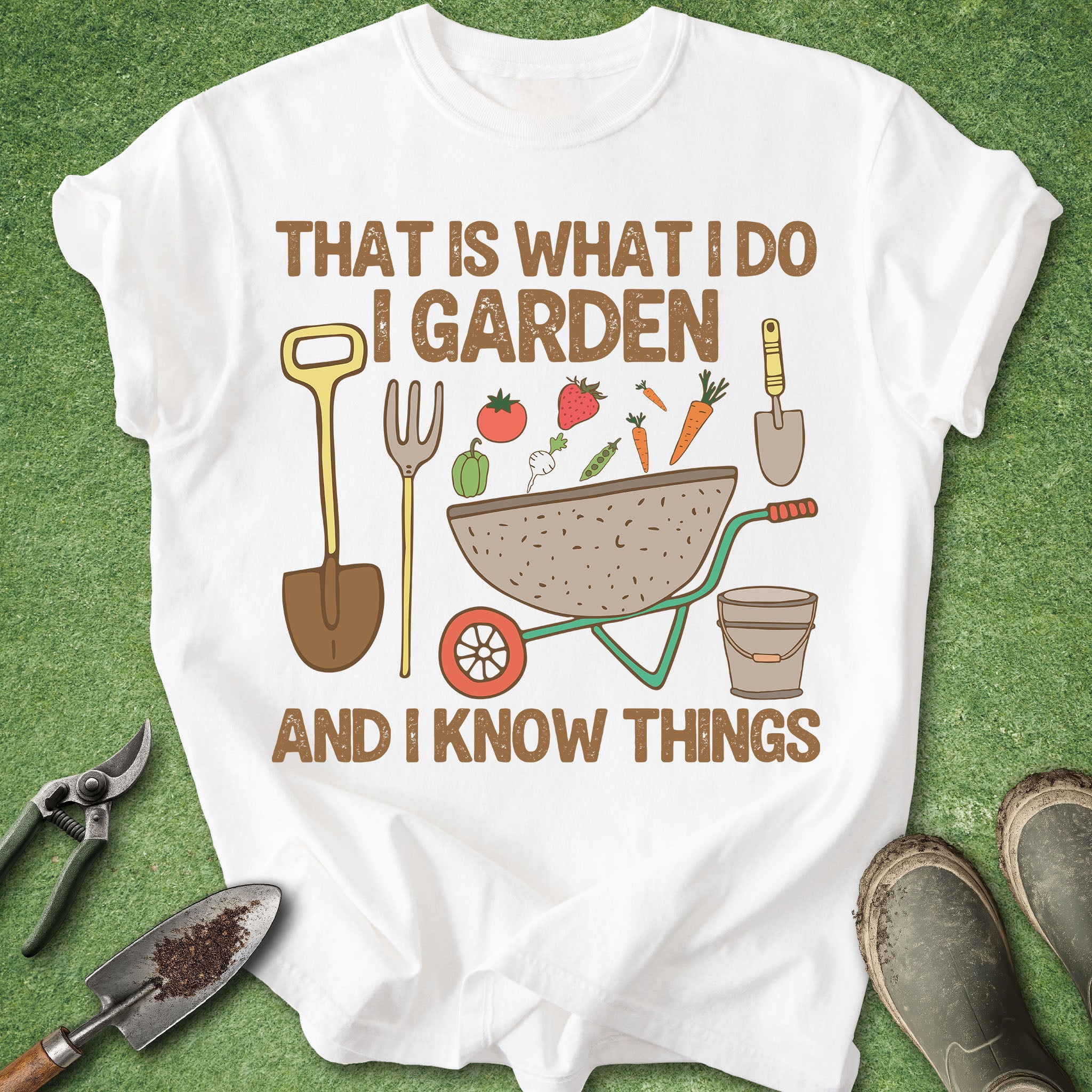 White t-shirt with gardening-themed design and tools on a green background