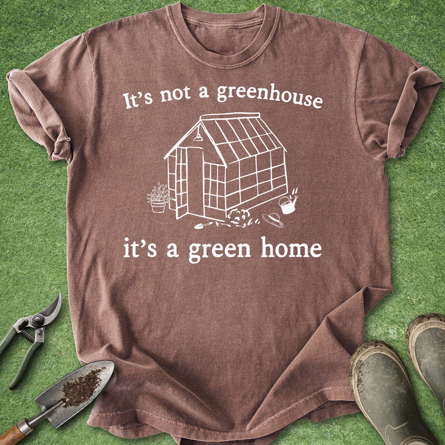 Minimalist greenhouse illustration with gardening tools and the text "It's Not a Greenhouse It's a Green Home" for gardeners, greenhouse owners, and plant lovers.
