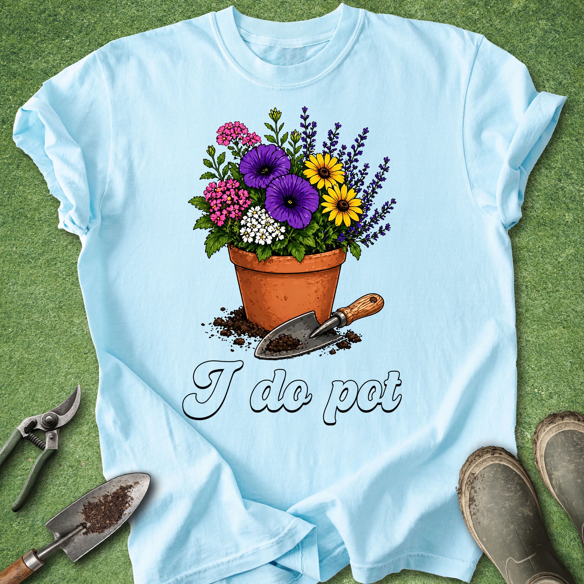 Light blue t-shirt with a flower pot and gardening tools graphic on a green grass background
