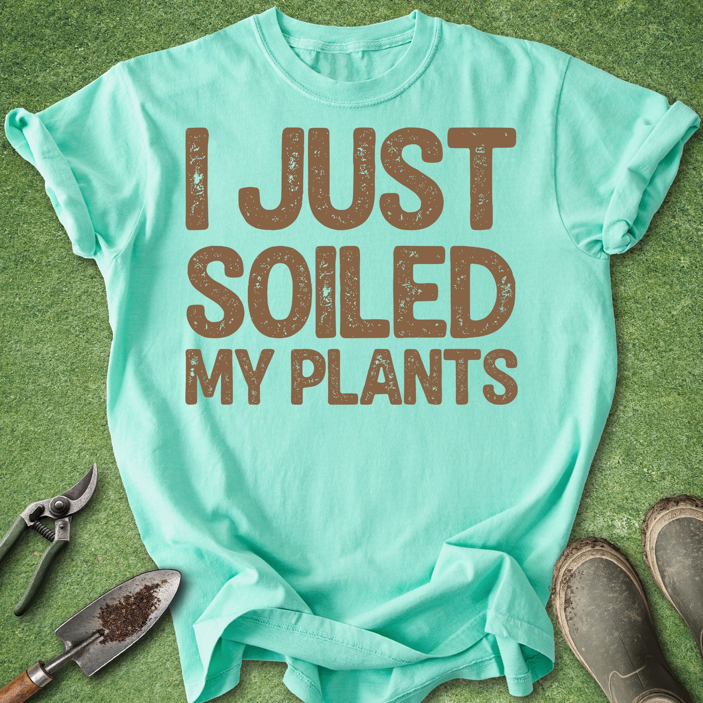 Mint green t-shirt with 'I Just Soiled My Plants' text on a grass background