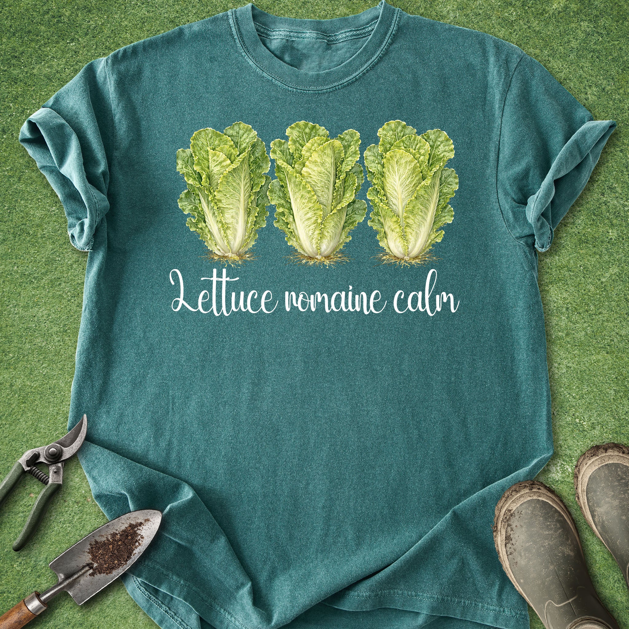 Teal t-shirt with lettuce graphic and text on a grass background