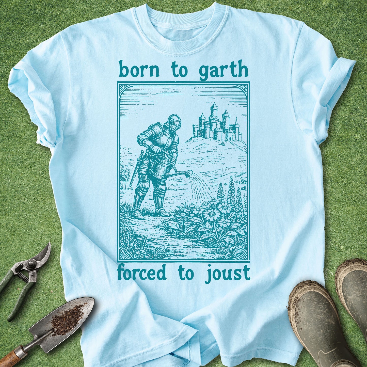 Light blue t-shirt with a graphic design and text on a grass background