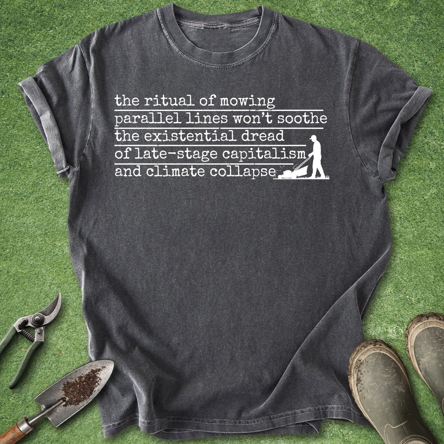 Gray t-shirt with text on a grass background with gardening tools.