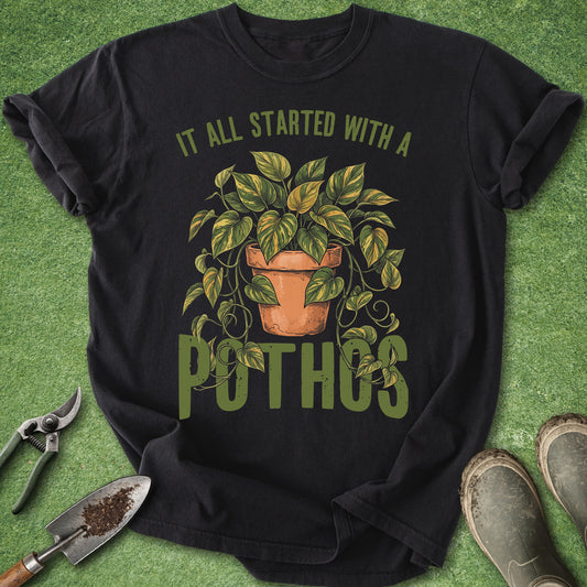 Funny houseplant shirt featuring a vintage-style potted golden pothos with trailing vines and the phrase "It All Started with a Pothos."