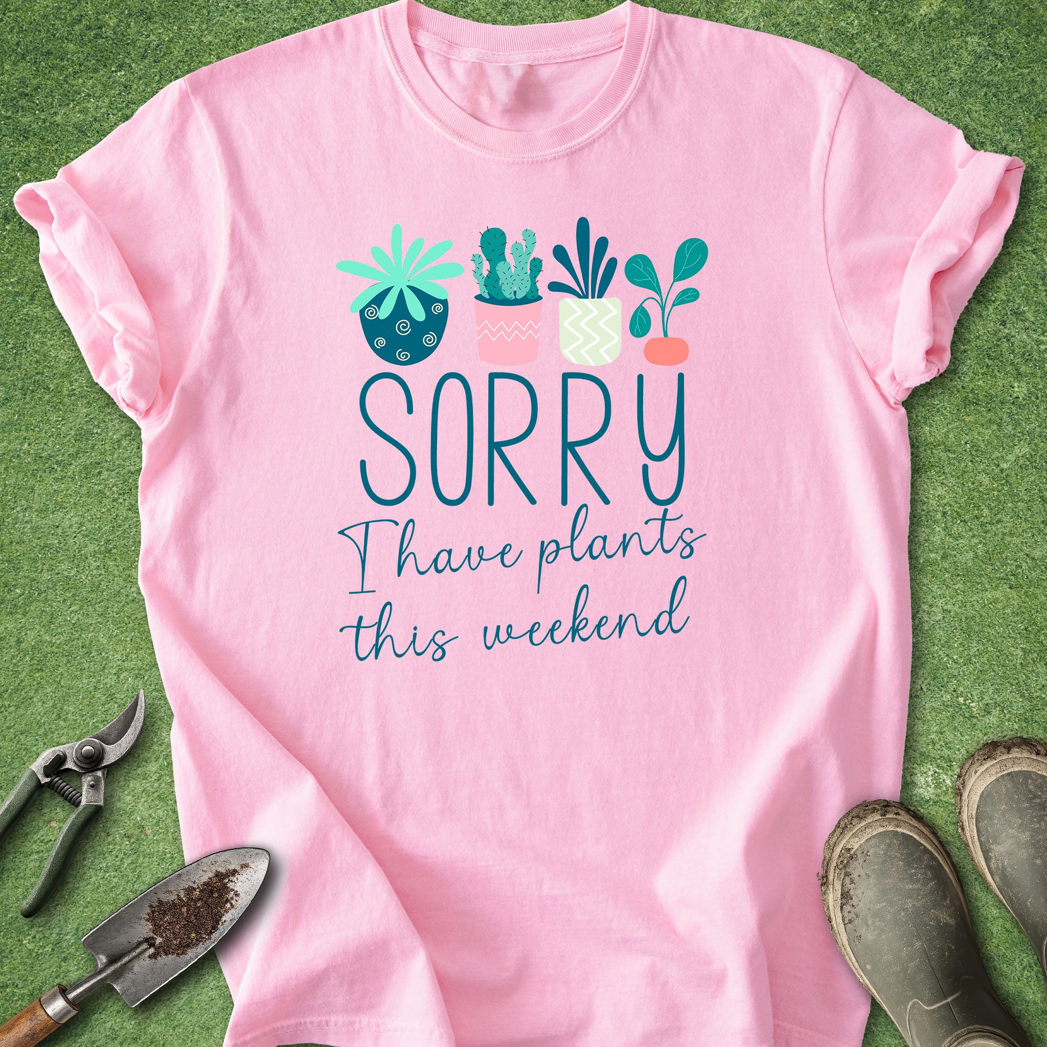 Pink t-shirt with plant-themed text on a green grass background