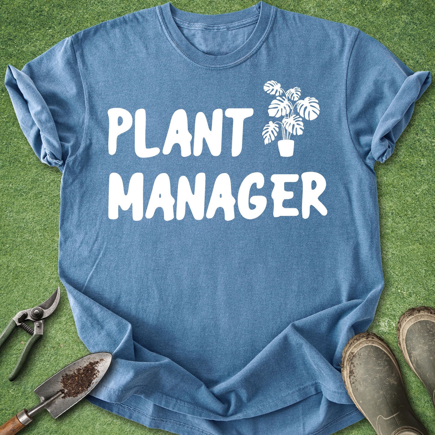 Blue t-shirt with 'Plant Manager' text and plant graphic on green grass background