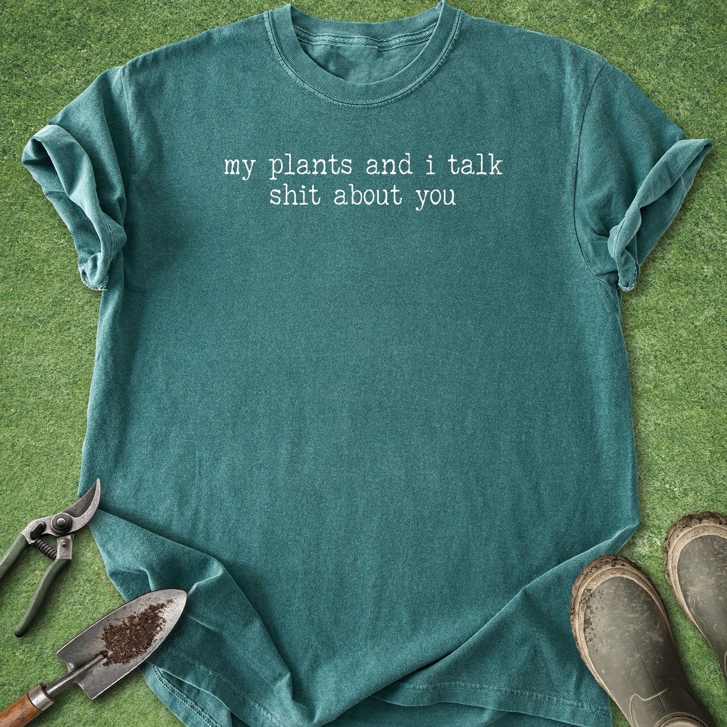 Comfort Colors Blue Spruce t-shirt featuring the funny quote "My Plants and I Talk Shit About You" in white vintage-style typewriter lettering.