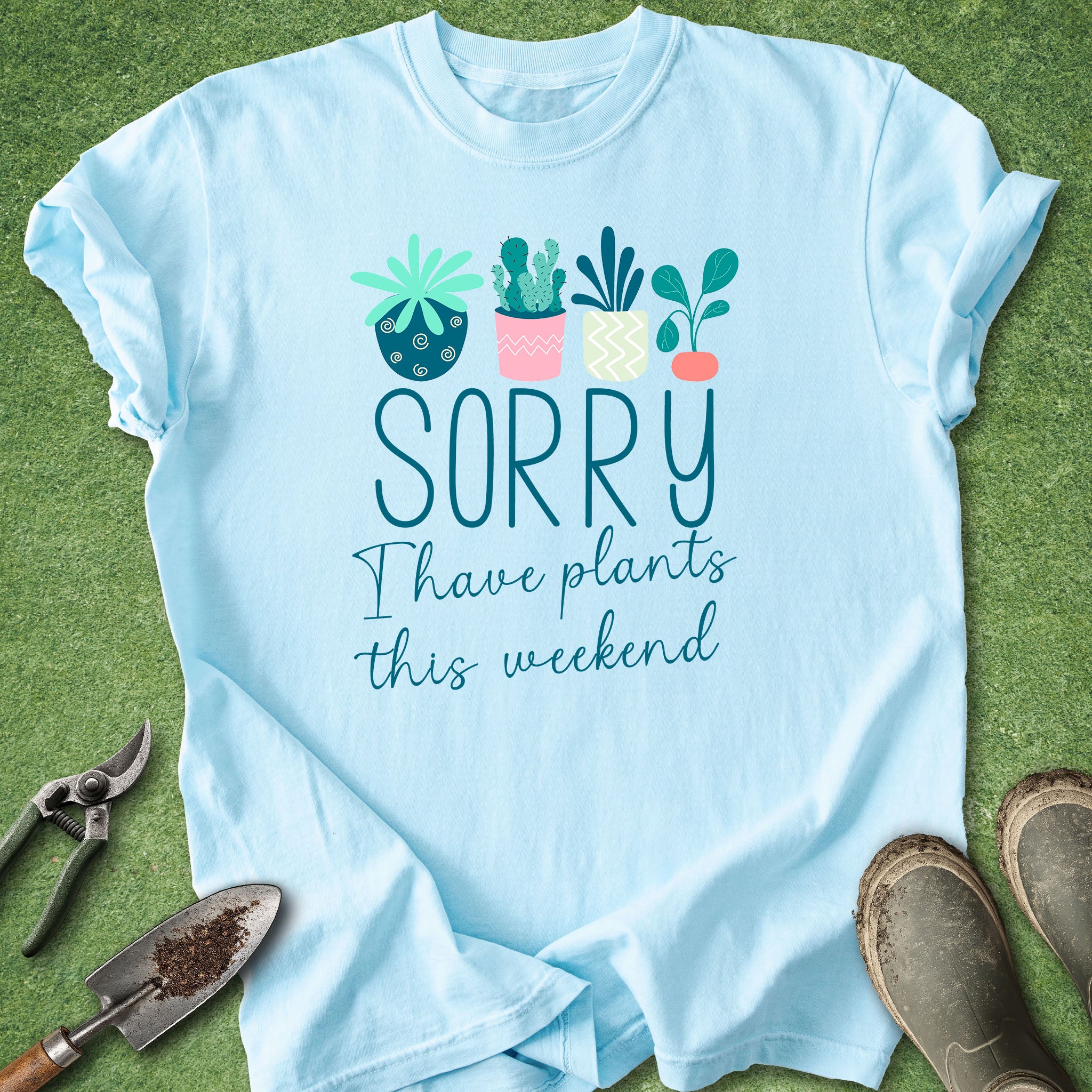 Light blue t-shirt with “Sorry I Have Plants This Weekend” text and illustrated houseplants