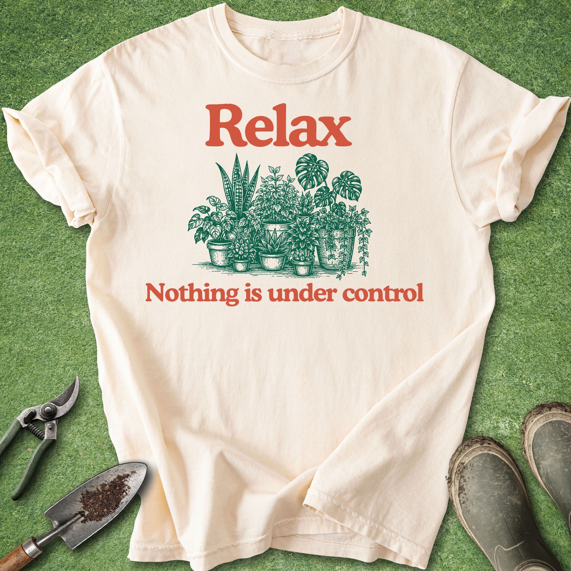 Comfort Colors ivory t-shirt featuring the phrase "Relax Nothing Is Under Control" above and below a vintage-style illustration of assorted houseplants in pots.
