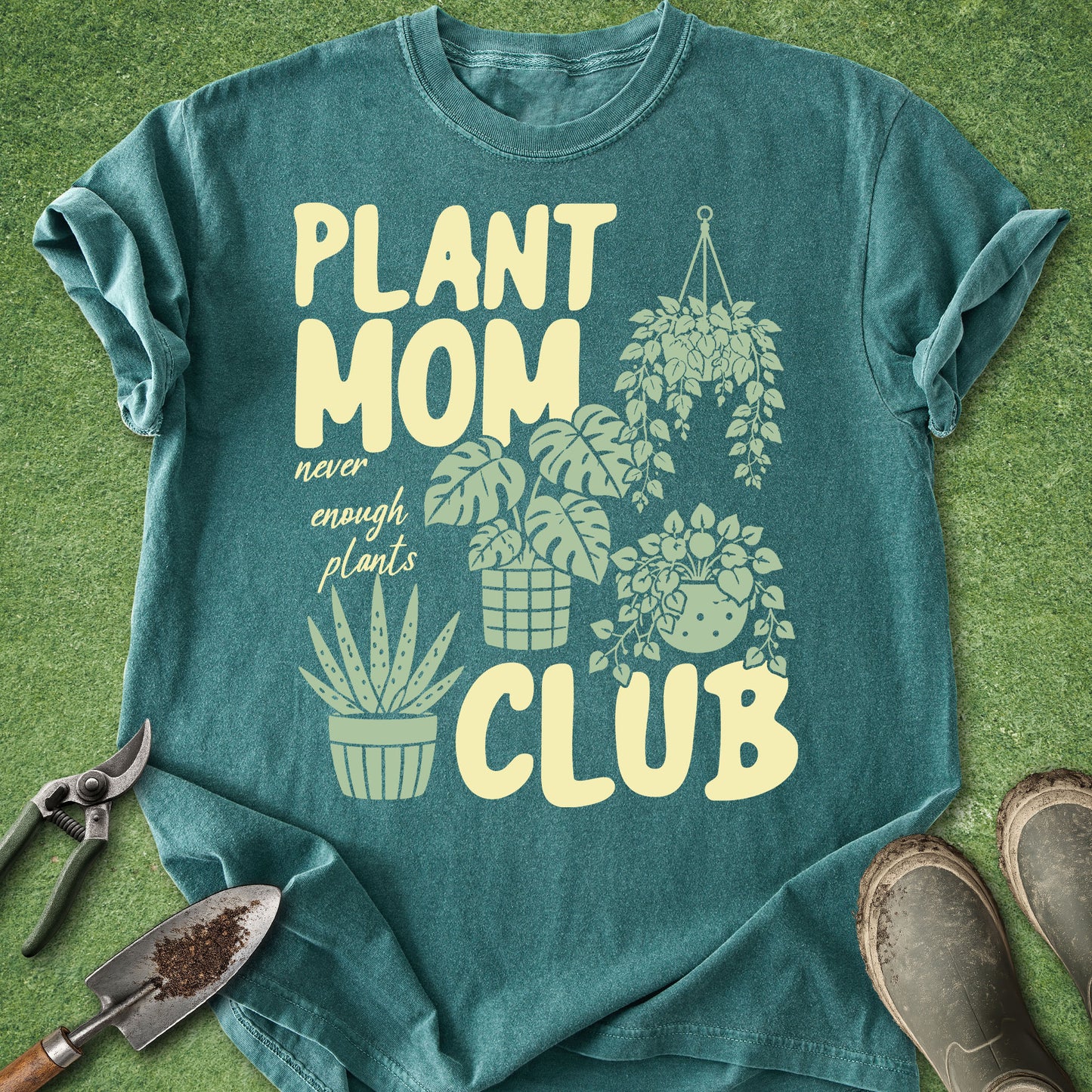 Teal t-shirt with 'Plant Mom Club' design on a grass background