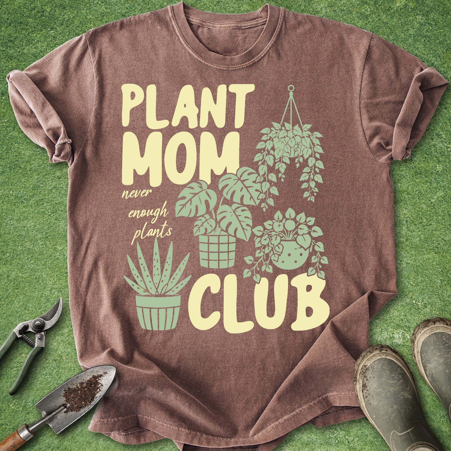 Brown t-shirt with 'Plant Mom Club' design on a green background